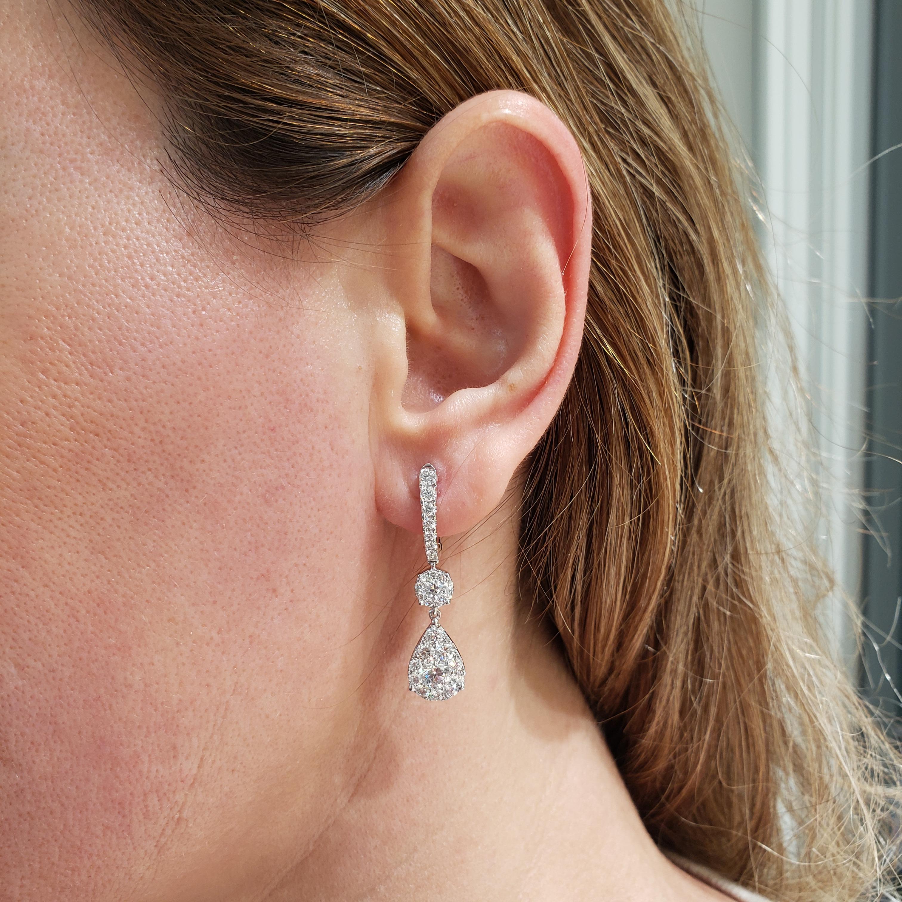 A stylish pair of earrings. Each earring showcases a GIA certified round diamond, set in a pear-shaped diamond halo. Suspended on a diamond halo and an accented diamond hoop. Diamonds weigh 2.85 carats total. GIA certified the center diamonds as