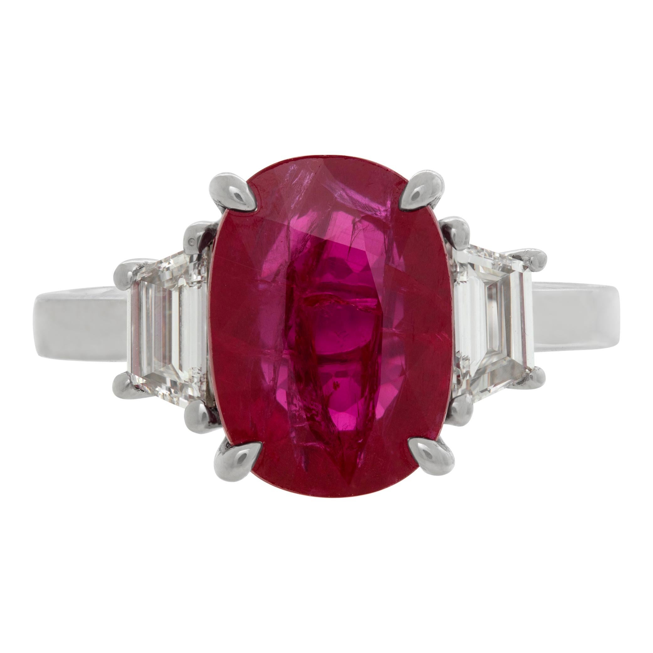 GIA Certified ruby & diamonds ring set in platinum. Brilliant oval cut ruby: 5.03 carats, with 2 trapezoid step cut diamonds, total approx. weight: 0.56 carat, estimate: G/H color- VVS/VS clarity. Size 7.This GIA certified ring is currently size 7