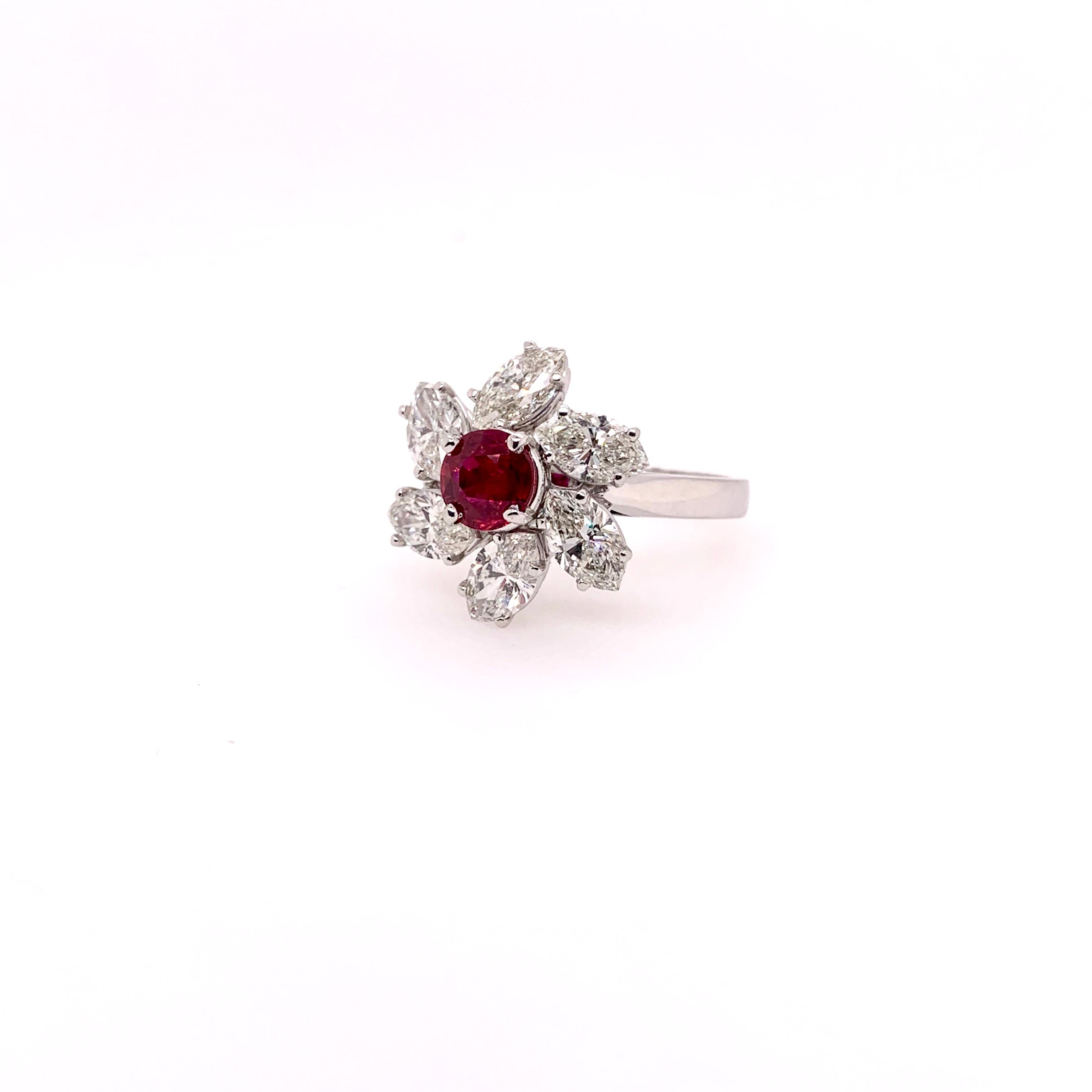 This stunning GIA certified heated ruby is the focal point in this mesmerizing custom setting in 18k white gold.  The large marquis diamonds weighs 2.75 carats and  surround the ruby like a pinwheel motif.  The ruby is 1.14 carat and has a deep,
