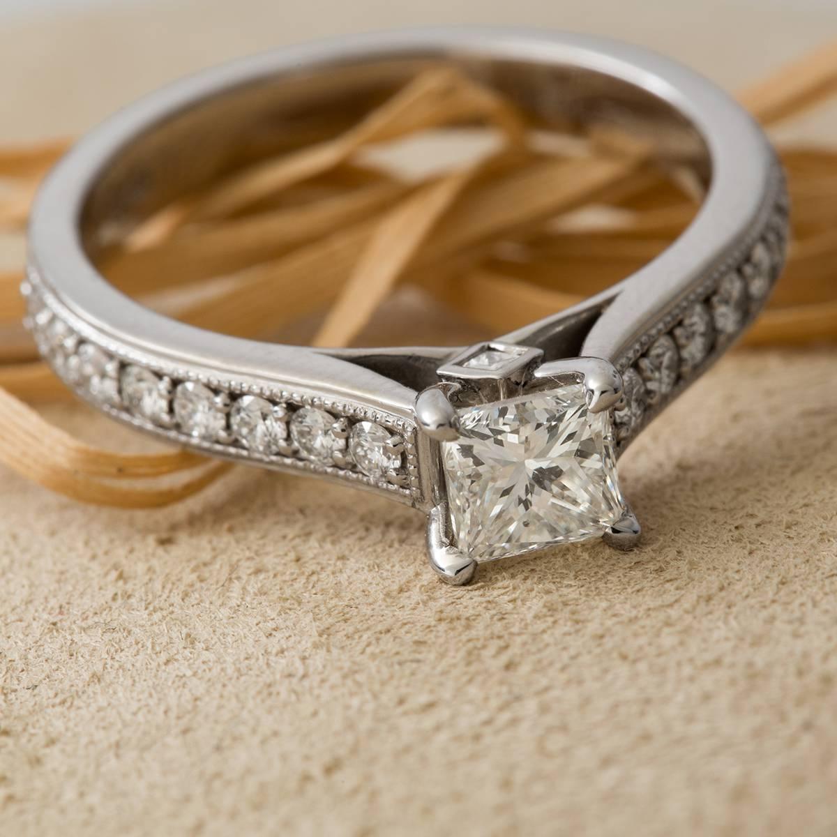 Signed Hamilton, 14 karat white gold and princess cut diamond engagement ring. Princess Cut weighs .64 cts and features a J color, VS1 clarity.  The band features 16 Round diamonds weighing a total of 37 cts. GIA certified. Size 6. 3/4 can be sized