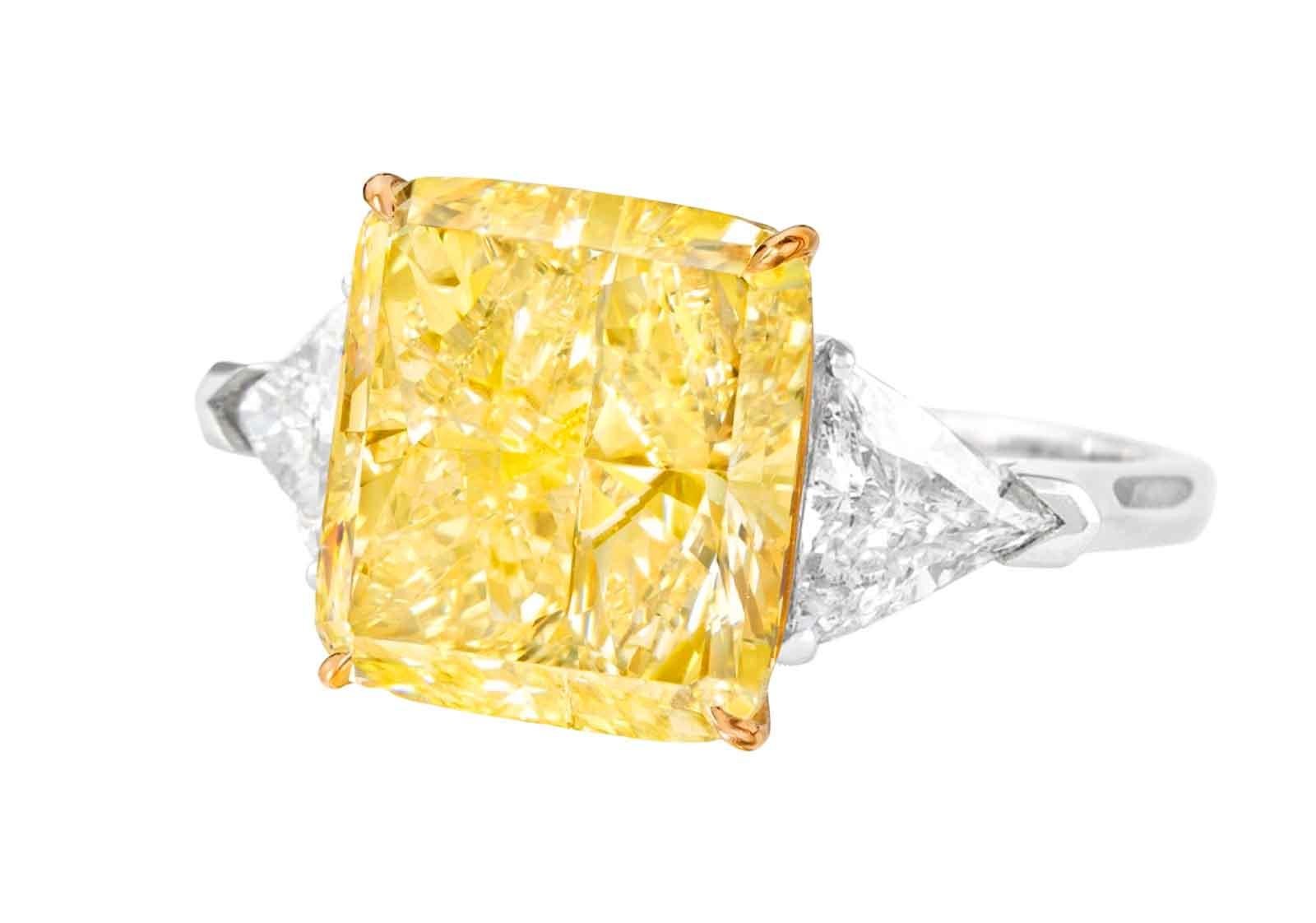 This luxurious ring is centered around an extraordinary 4.32 ct Cushion Modified diamond, a jewel of unmatched allure and distinction. Certified by the Gemological Institute of America (GIA), this diamond boasts a Fancy Intense Yellow color, a rich