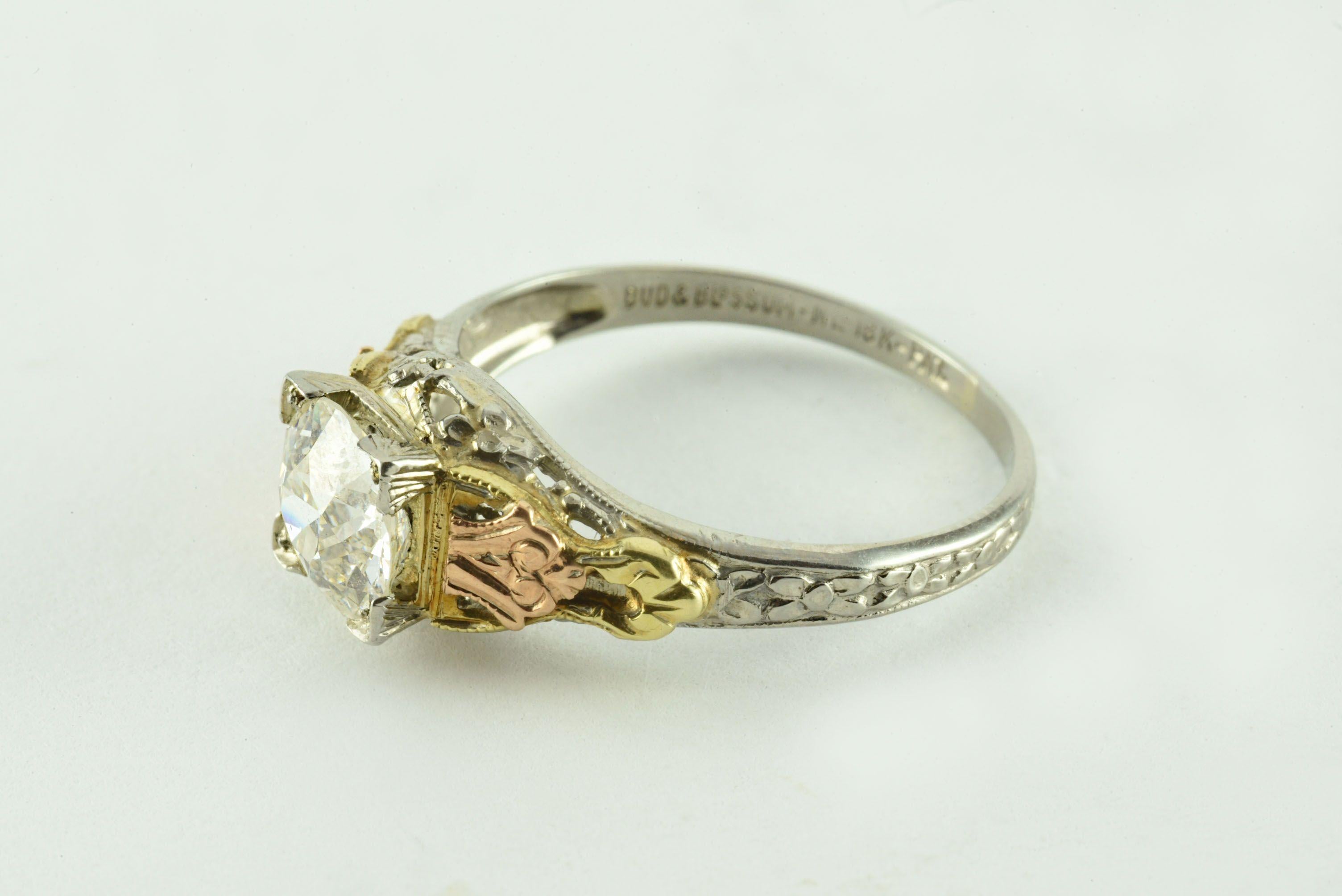 This antique stamped “Bud and Blossom” ring from the 1930s features an Old European cut diamond measuring 1.04 carats, J color, SI1 clarity and set in platinum with 18kt yellow gold and 18kt rose gold sides. 
