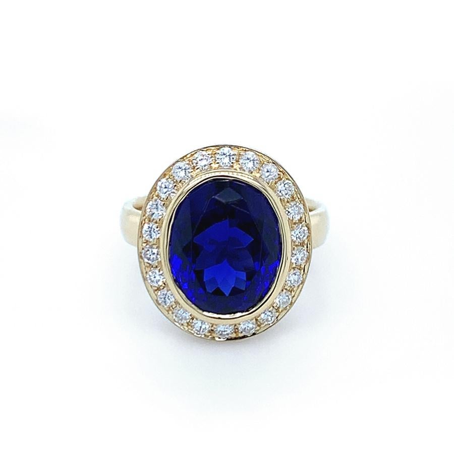 Ring with a wonderful Tanzanite of 7.37 carats, cut in oval shape (modified brilliant cut),  blue-violet color, eye-clean. The oval bezel is set with 22 diamonds totaling approximately 0.51 carats, color: G (Top Wesselton), clarity: VS (only very