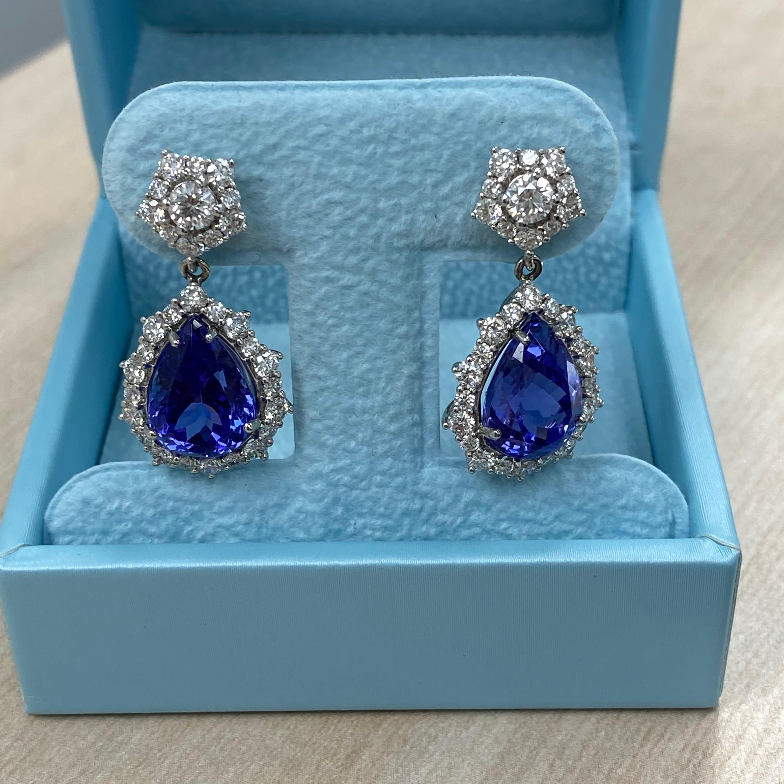 These exquisite earrings feature stunning pear-shaped tanzanites, weighing 4.41 and 4.76 carats respectively, in a deep, rich violet hue. Each tanzanite is beautifully framed by a halo of sparkling diamonds, with G/H color and VS/SI clarity. The