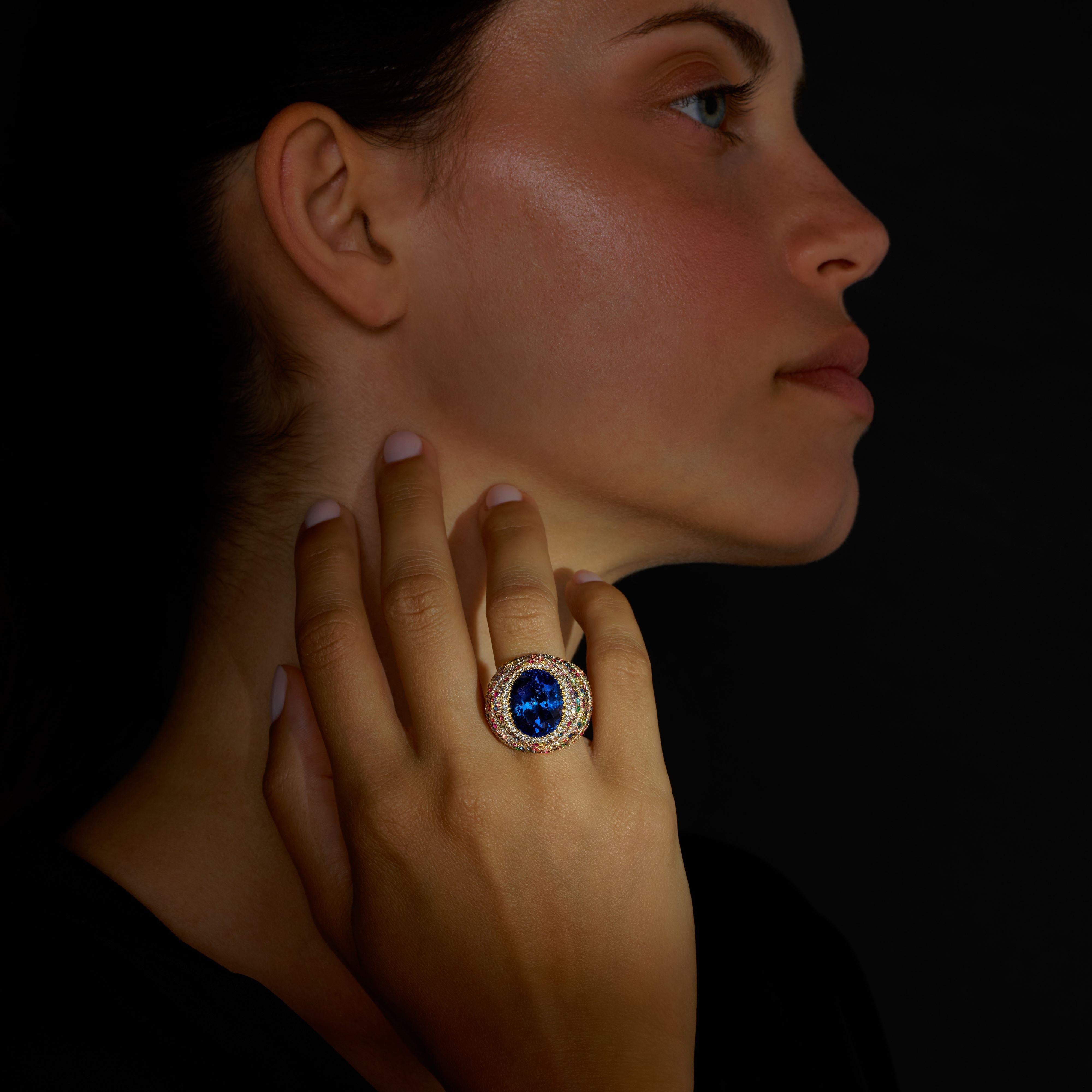 Rosior One-off Cocktail Ring set in Yellow Gold with:
- 1 oval cut, GIA certified, tanzanite weighing 11,86 ct.
- 153 multicolor sapphires weighing 2,98 ct;
- 108 colorless diamonds (F color, VVS clarity) weighing 0,94 ct;
- 33 pink sapphires