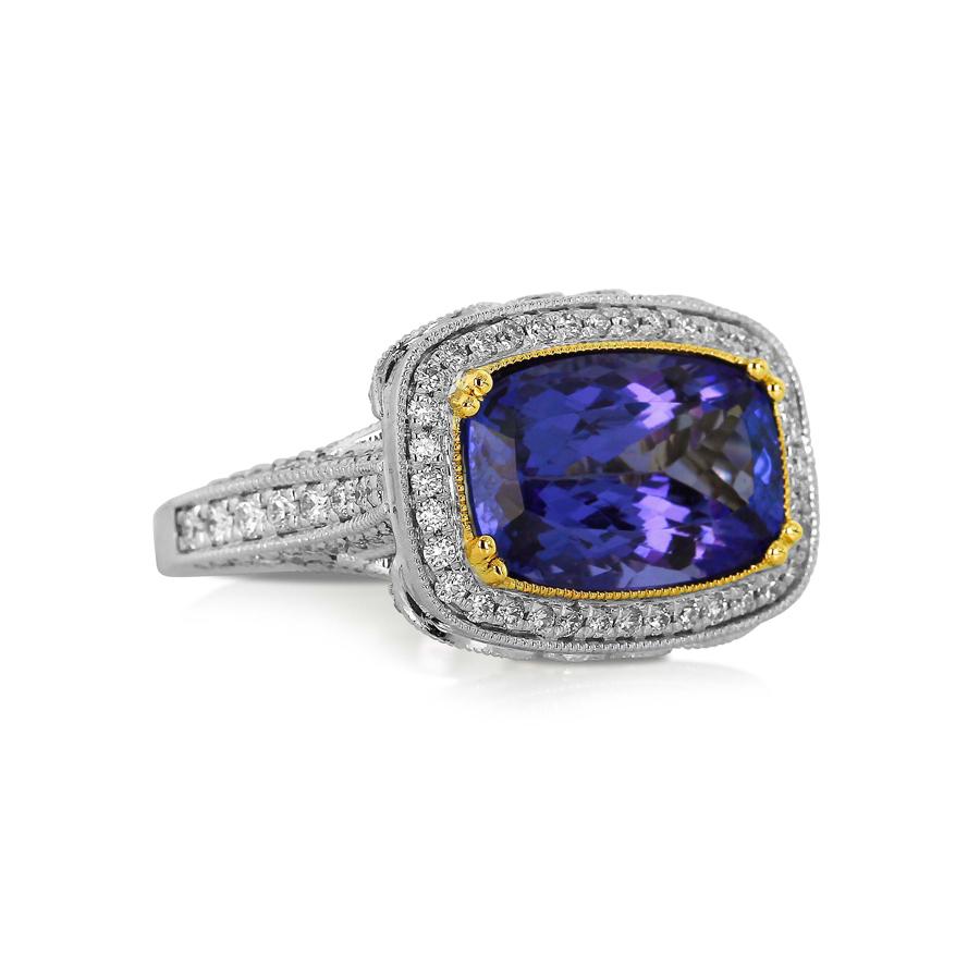 This magnificent ring features a richly-toned tanzanite in a diamond-encrusted ring composed with such stunning detail as to create a sensational design. Yellow gold is used to accent the tanzanite and pick out detail in the undercarriage, while