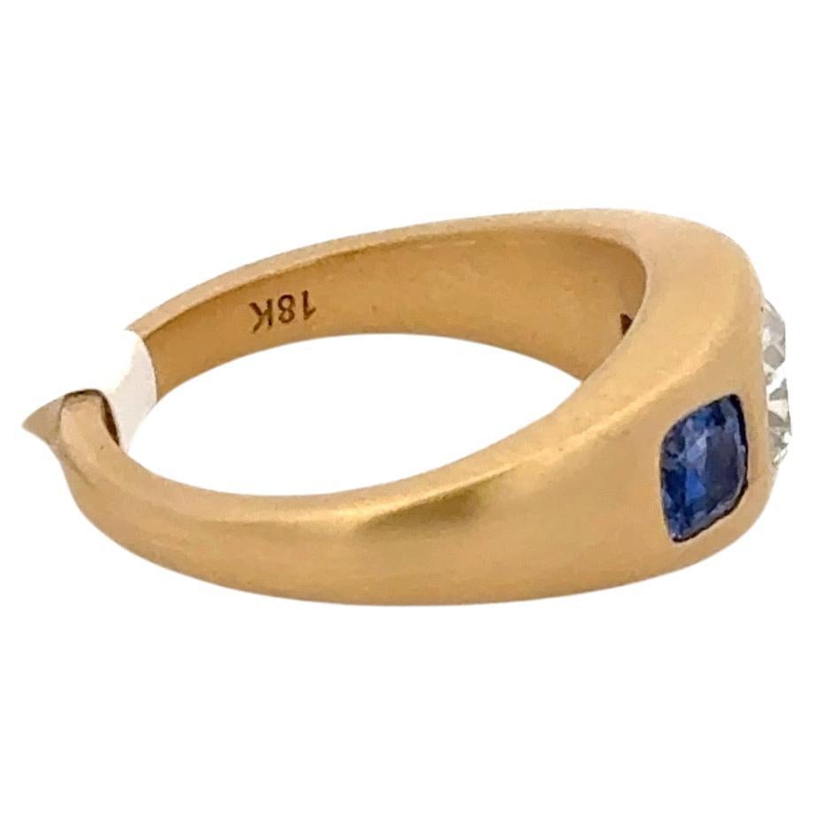 Bague gitane à trois pierres en or jaune 18 carats, composée d'un diamant coussin certifié GIA et de deux saphirs de taille coussin. 

Certifié GIA
0,81 carats 
Couleur I
Clarté VS1

Les saphirs pèsent 0,83 carats