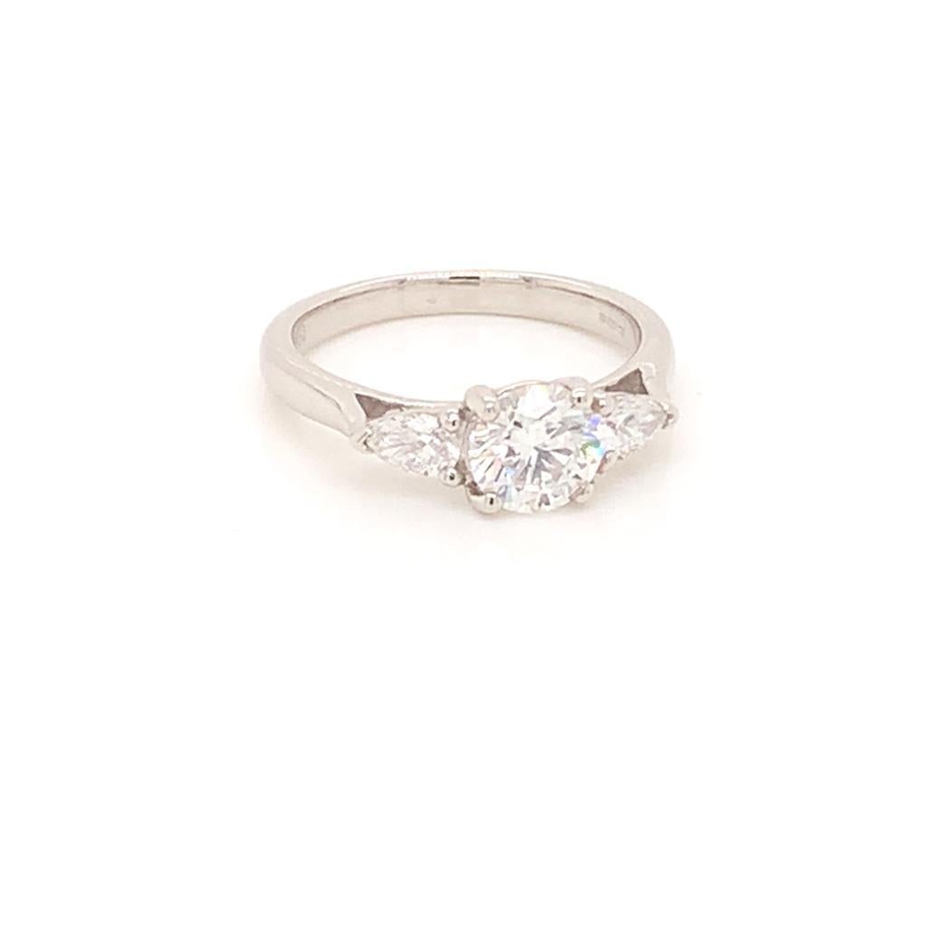 This stunningly captivating ring from our Treasure Collection features a 0.90 Carat Round Brilliant diamond of E colour and VVS2 clarity at its centre, making it flawless to the naked eye. It is accompanied by 2 pristine pear-shaped diamonds