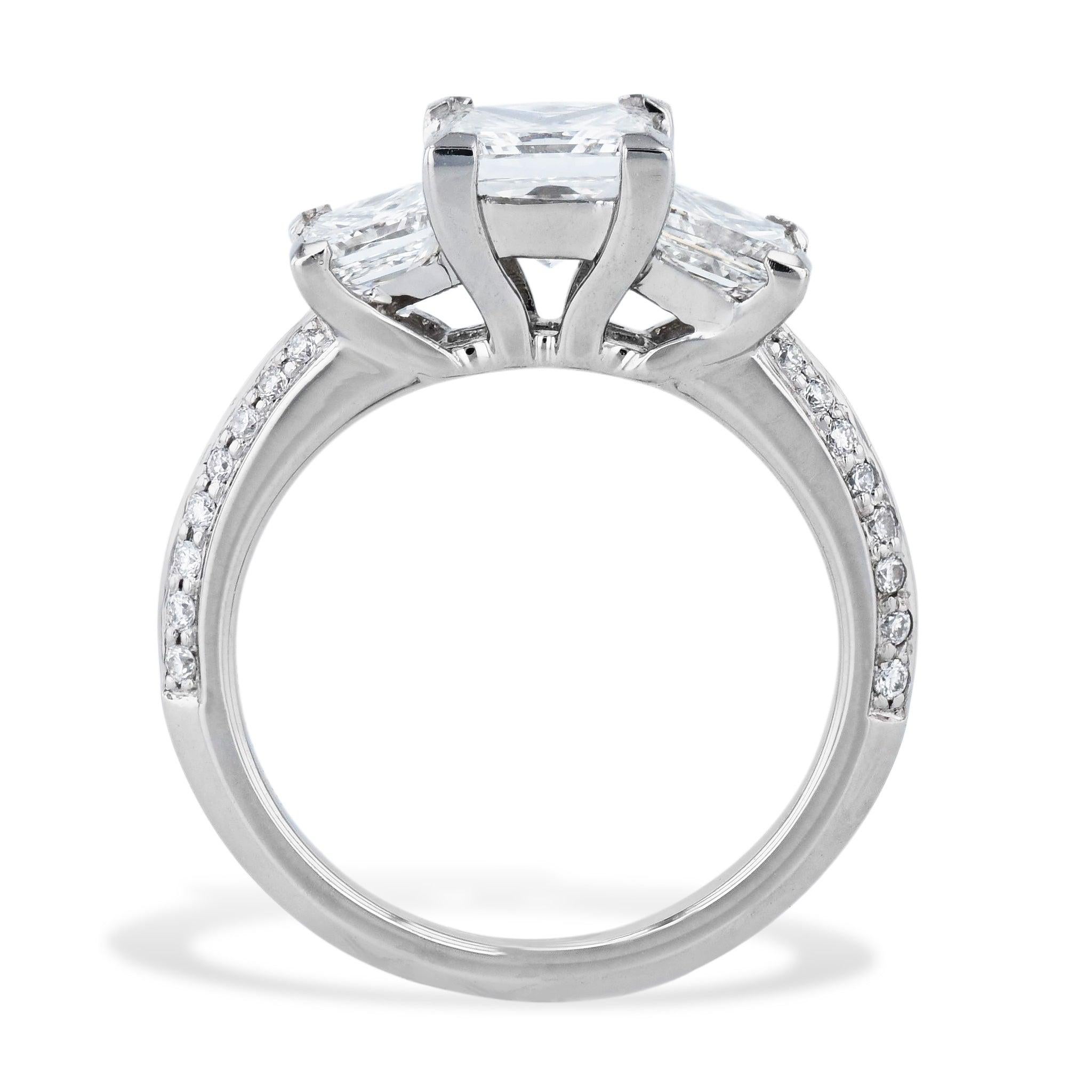 Showcase your eternal love with this stunning Platinum 3 Princess Cut Diamond Engagement Ring. The gleaming center diamond  is flanked by are two brilliant diamond side stones, and a diamond pave of 32 stones down the shank. This exquisite piece is