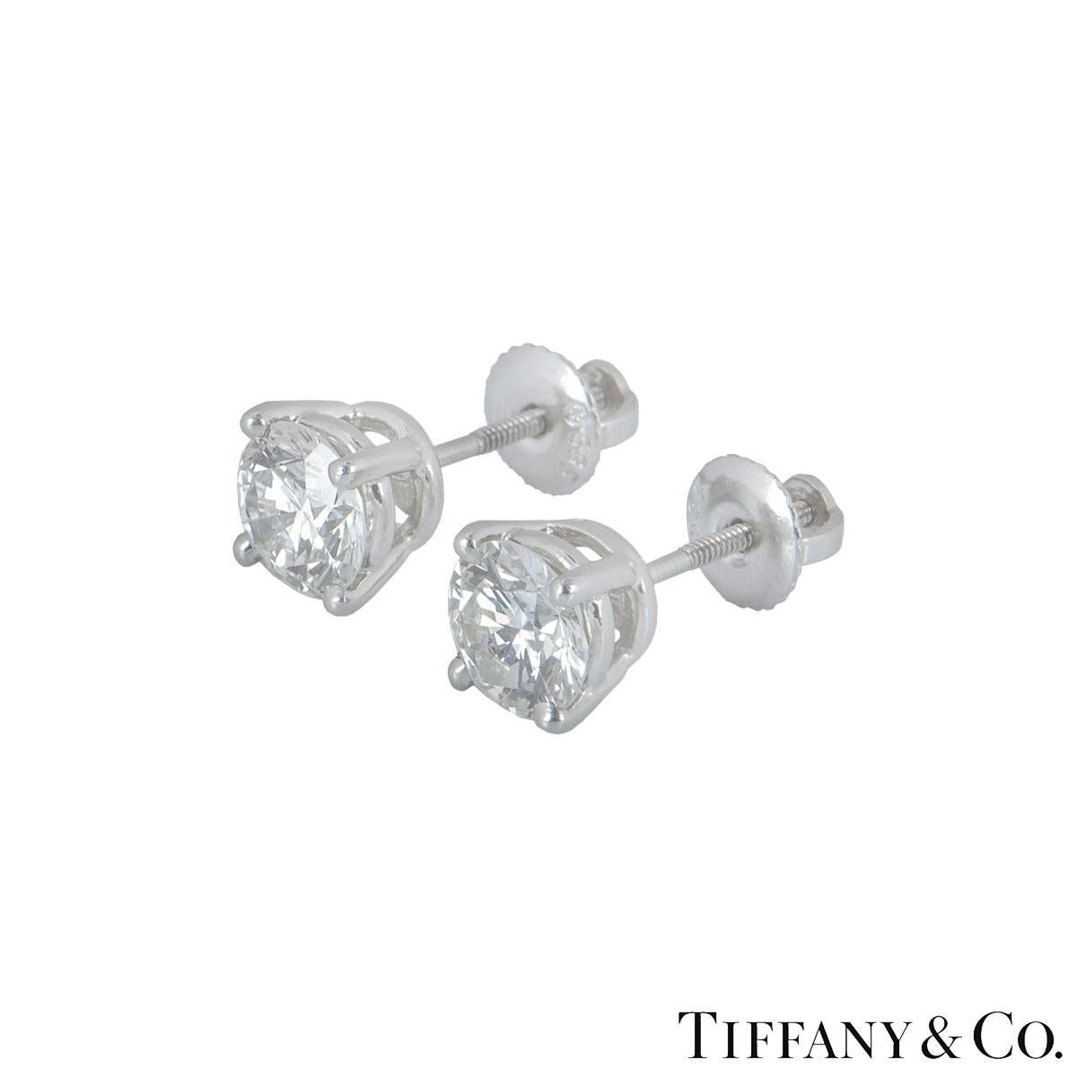A stunning platinum pair of diamond ear studs by Tiffany & Co. Each earring is set with a round brilliant cut diamond in a four claw setting, one weighing 1.02ct and the other 1.00ct both I colour and VS1 in clarity. The earrings feature a post and