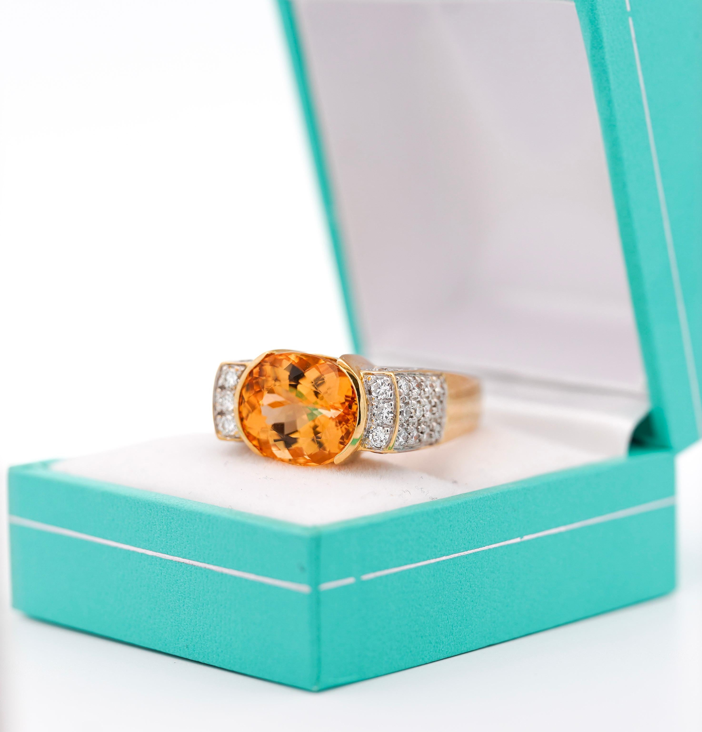 GIA certified vintage geometric Natural Orange Topaz and Diamond Ring, set in 18K Yellow Gold.

This lovely cocktail ring boasts a brilliant oval-cut orange topaz center stone in half bezel setting, and round-cut diamond side stones. This ring is