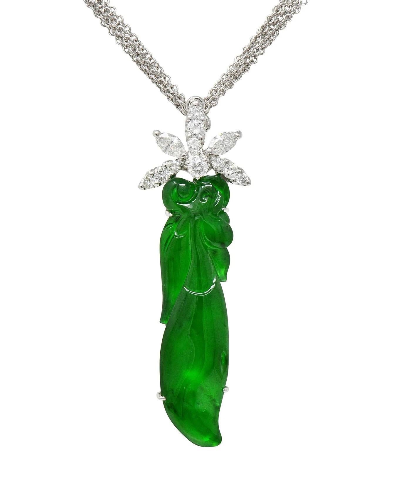 A beautiful and glowing example of fine quality Type A Green Jadeite, simplistically & auspiciously carved.
The Jadeite is mounted in 18K White Gold with a hinged exhibition compartment window on back and bale cluster mounted with Marquise & round