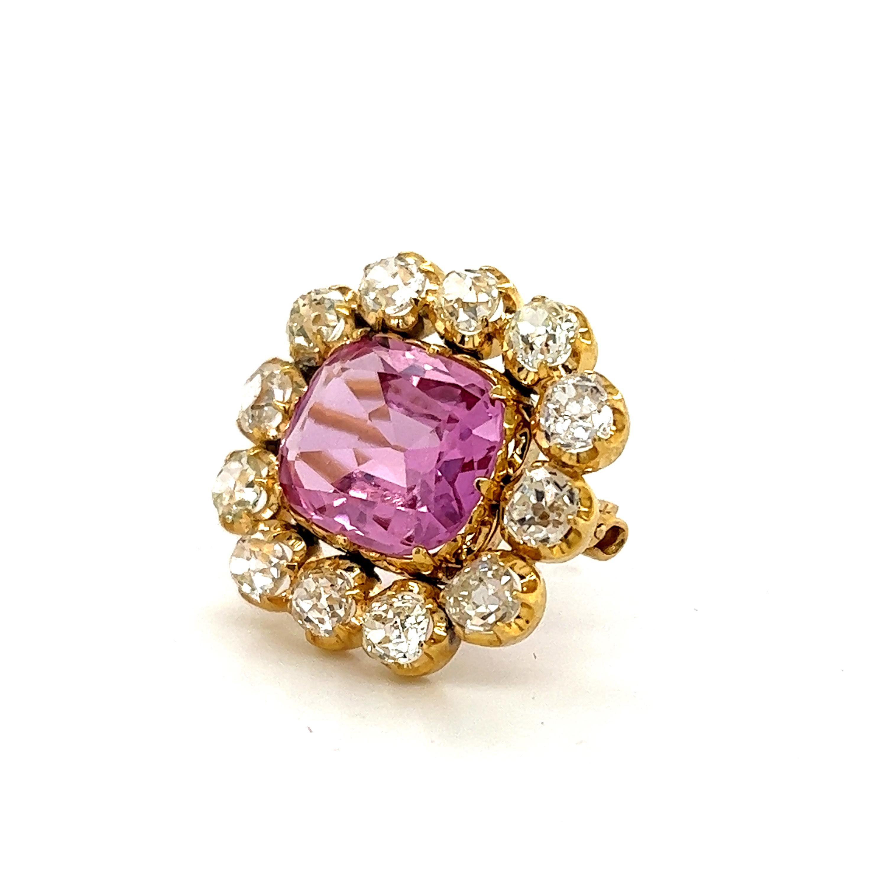 Beautiful Victorian brooch crafted in 18k yellow gold. The brooch is set with one Pink Topaz gemstone, known in the trade as Imperial Topaz. The gemstone displays a vibrant pink color and and pops off the yellow gold design. To find a natural pink