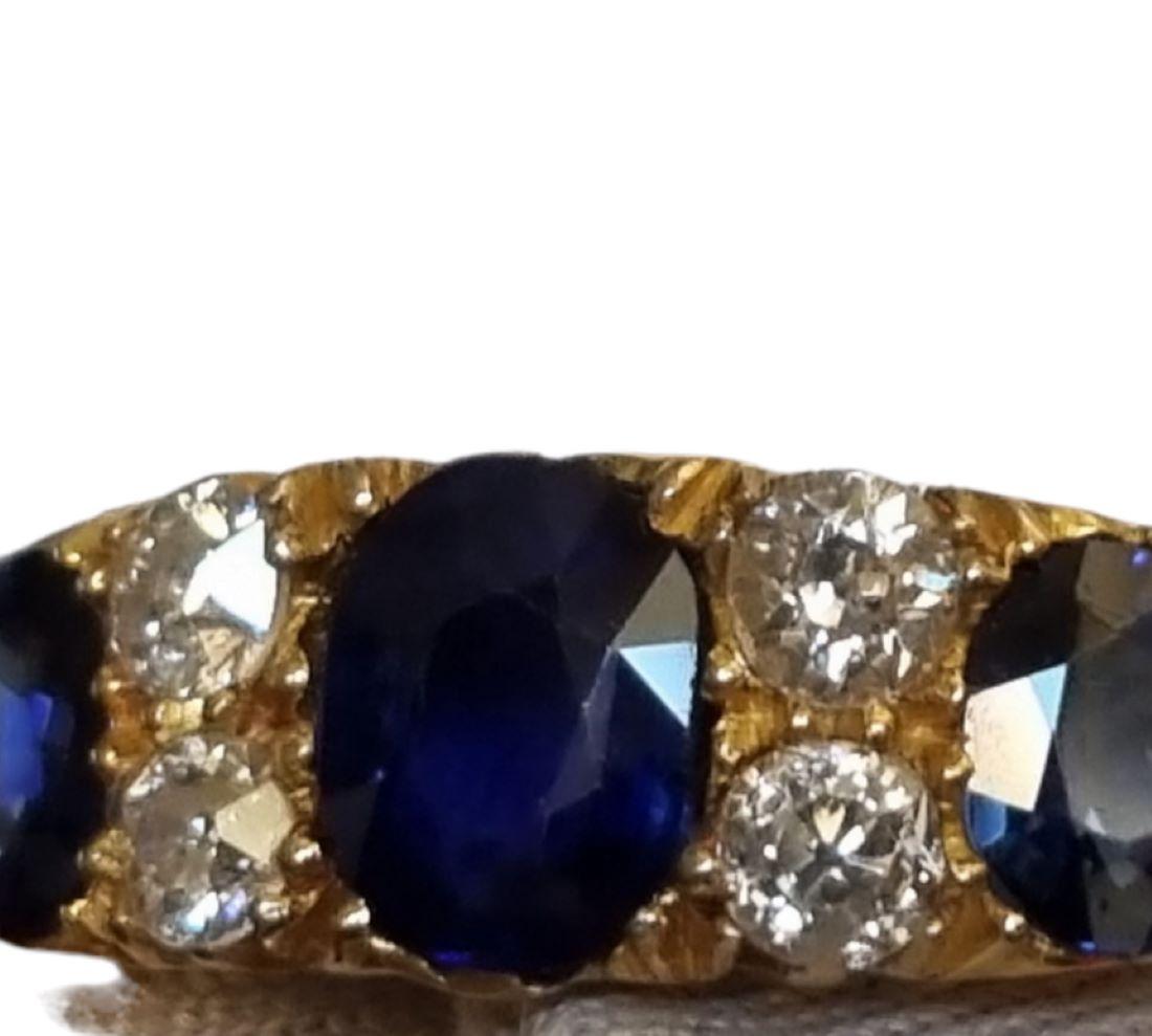 Three Stone No-Heat Blue Sapphire, Diamond Ring (GIA certified)
A trio of radiant royal blue sapphires (natural, no-heat)--a cushion-cut and two rounds--is interspersed with pairs of bright white and sparkling European-cut diamonds, in this classic