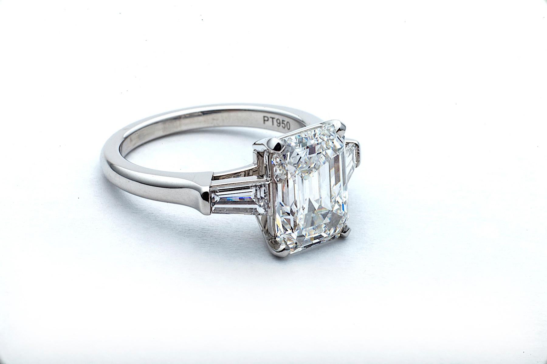 Looking like pure sparkling ice, this spectacular vintage emerald cut diamond engagement ring has a one-of-a-kind personality. Designed with a handmade platinum mounting, its sleek and elegant 3.46 carat, E color, VS2 clarity,  center diamond is