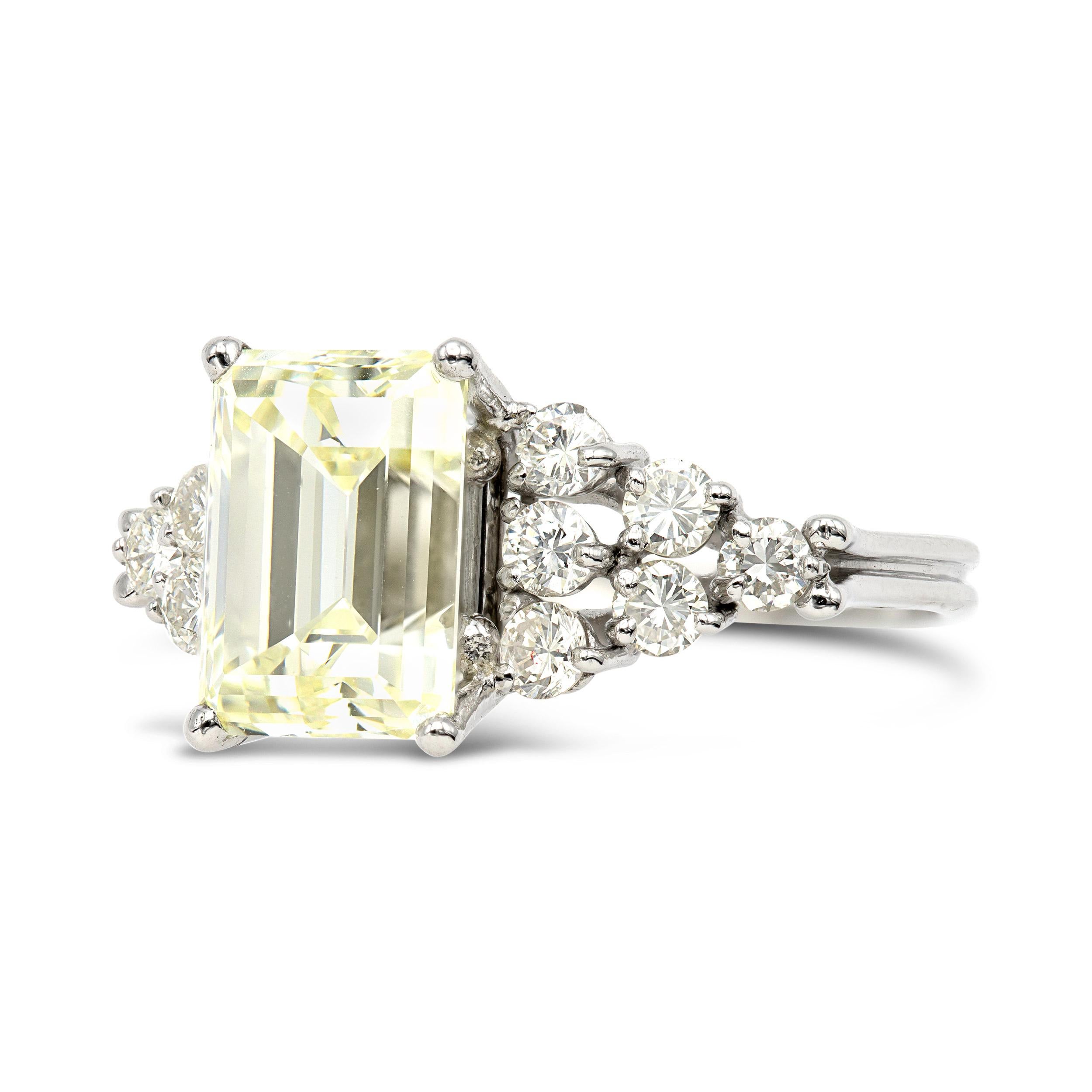 This engagement ring hosts a massive emerald cut diamond that seriously packs a punch. The center 4.15 carat, GIA certified, has those crispy faceting and proportions that we love to see in a vintage step cut. Flanked by clusters of old Euros, this