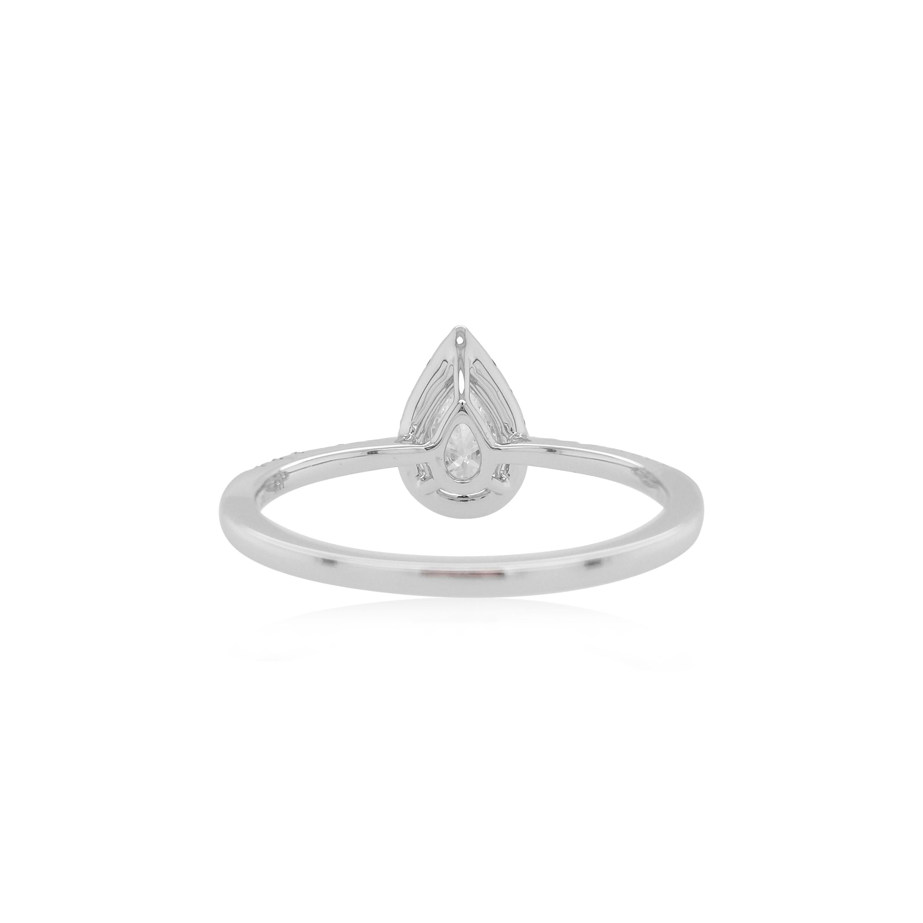 Cette magnifique bague présente en son cœur un diamant blanc exceptionnel, le tout serti dans de l'or blanc 18 carats et accentué par un halo de diamants verts étincelants. Parfaite pour un usage quotidien, la beauté de cette bague réside dans sa