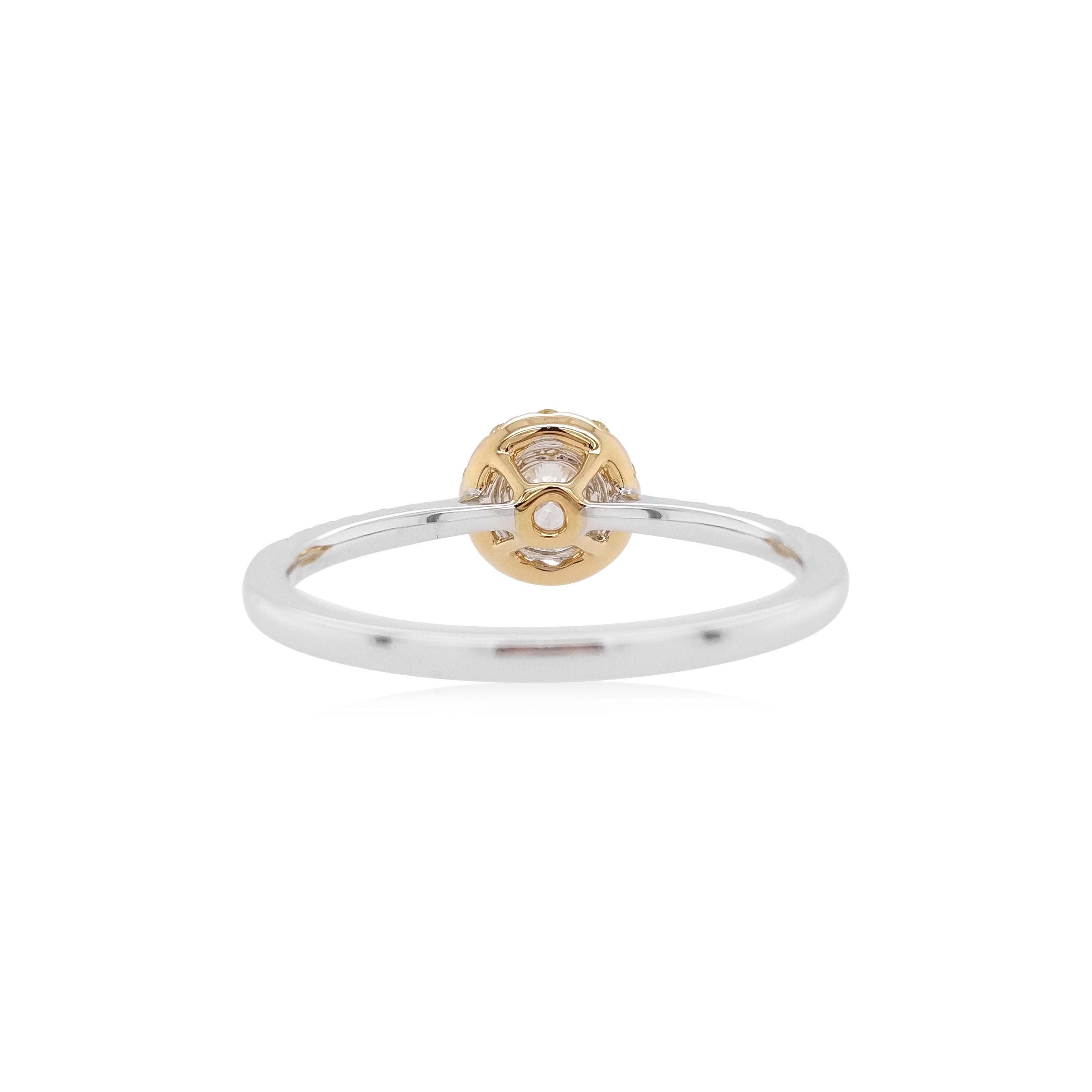 This elegant ring features an excellent quality round-shaped white diamond at its center, with a delicate yellow diamond halo surrounding it. Set in 18 Karat white and yellow gold to enrich the spectacular hues and the sparkle of the diamonds, this