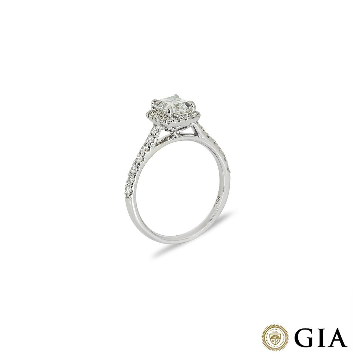 A modern 18k white gold diamond engagement ring. Set to the centre of the ring is an emerald cut diamond weighing 1.08ct, F colour and VS1 clarity. Accentuating the centre diamond are 32 round brilliant cut diamonds pave set to the halo and