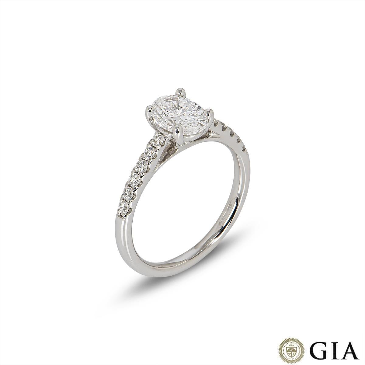 A stunning 18k white gold diamond engagement ring. The ring is set to the centre with an oval cut diamond weighing 1.00ct, D colour and SI1 clarity. The centre diamond is further complemented with 12 round brilliant cut diamonds set to the shoulders