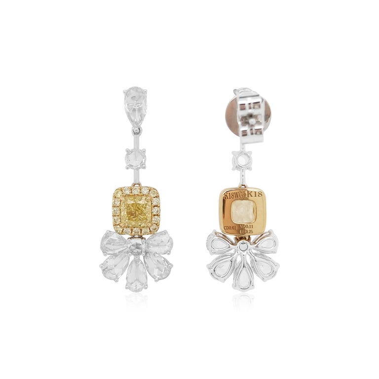 These mesmeric 18K gold earring feature natural Fancy Yellow Diamonds at its centre, surrounded by a halo of small yellow diamonds, perfectly accentuated by delicate arrangement of round and pear shapes Rose-cut white diamonds. Bold, yet intricate,
