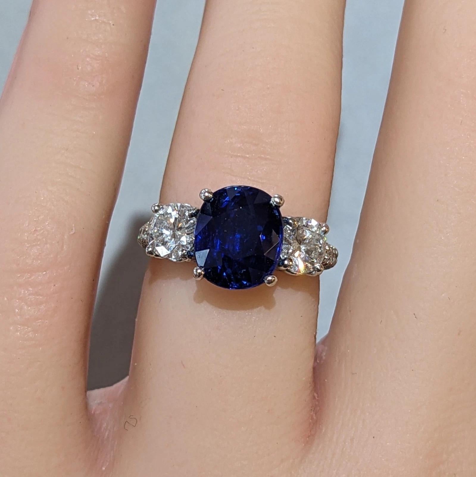 GIA Ceylan non chauffé 3(95) ct Saphir coussin Bague à trois pierres en platine 

La bague saphir et diamant présente un saphir bleu profond certifié GIA à taille coussin pesant 3,95 carats, accentué par deux diamants ronds de taille brillante plus