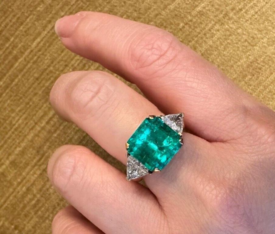 GIA Certified Colombian 7.72 carat Emerald in Three Stone Ring in 18k Yellow Gold 

Emerald and Diamond Three Stone Ring features a 7.72 carat Natural Green Colombian Emerald with a Square Step-cut, accented by 2 Trillion-cut Diamonds on the sides,