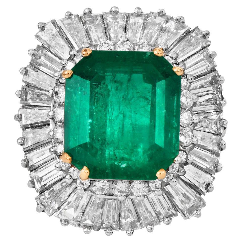 A true showstopper, this ballerina-style cocktail ring centers a mesmerizing GIA-certified Colombian emerald, weighing approximately 7.44 carats. The vibrant octagonal step-cut emerald radiates with rich green intensity and is set in luxurious 18K