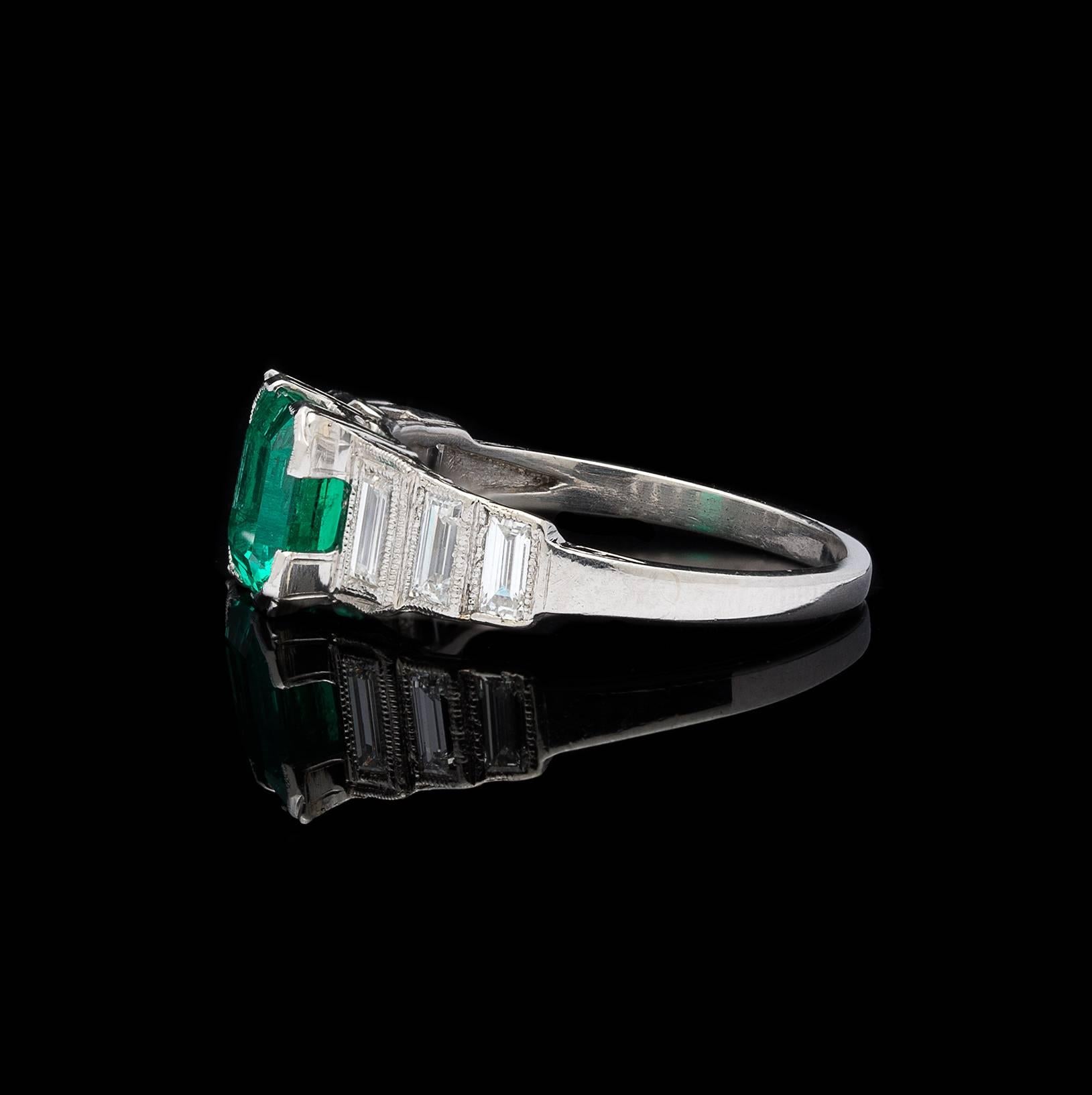 This elegantly designed ring showcases a bright and beautiful example of a high quality Colombian emerald. A gorgeous blue-green color and clean to the eye, the Octagonal Step-Cut Emerald weighs 1.37 carats, and is accented down the ring with 6