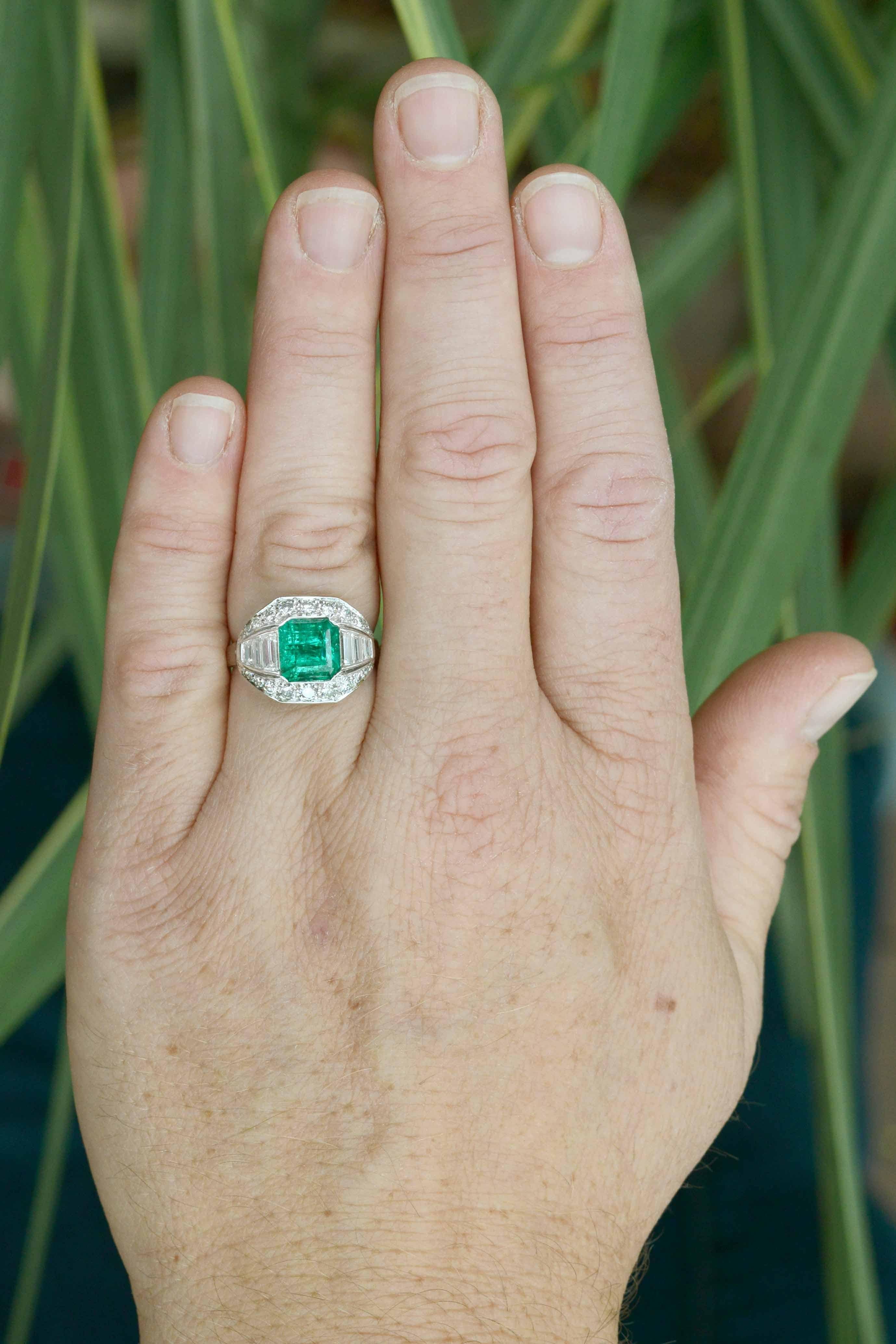 A sublime, certified GIA certified Colombian emerald engagement ring. This authentic, antique Art Deco masterpiece makes for a dynamic statement cocktail ring. Centered by a 2.40 carat step cut of a lush, vivid grass-green, it appears with such