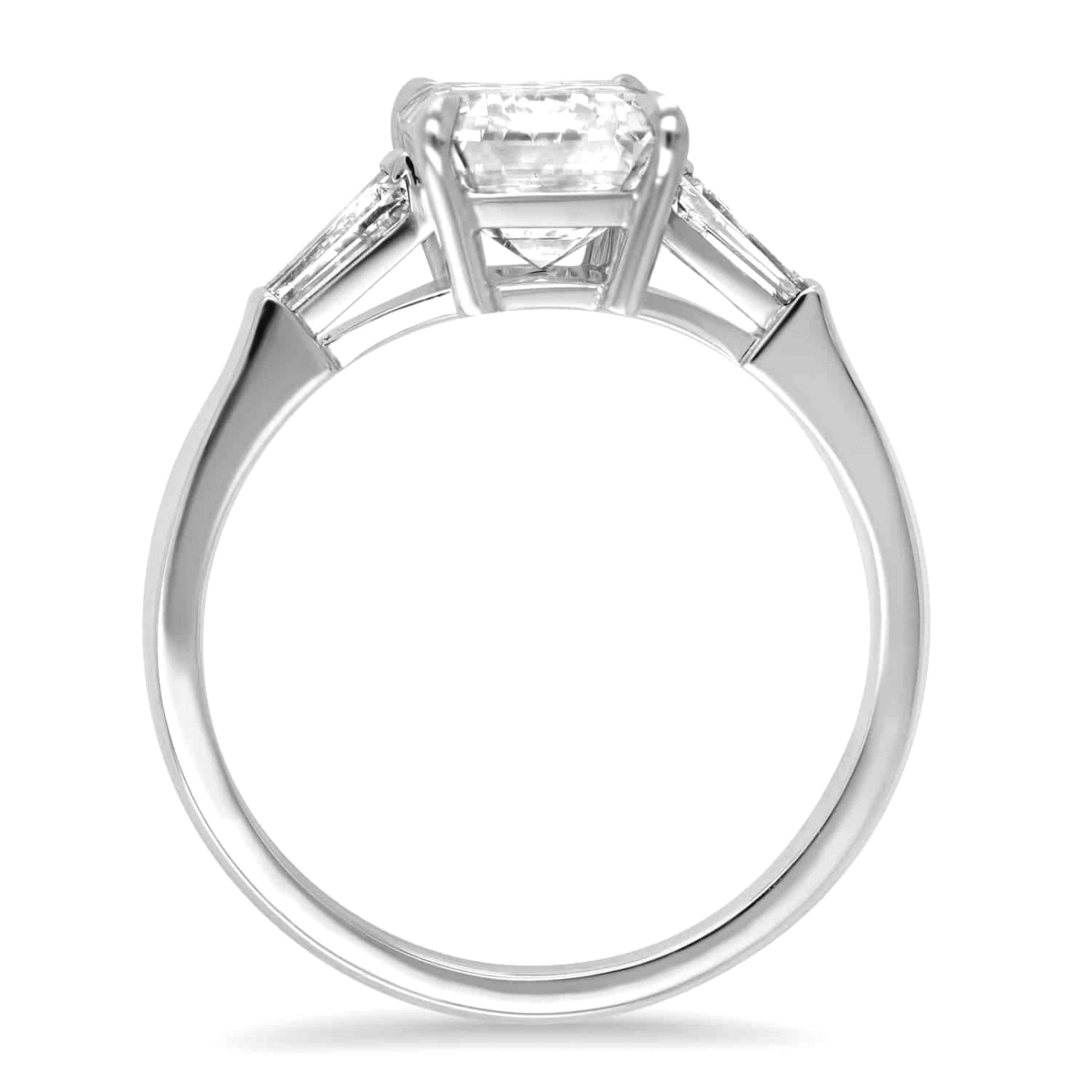 This 2 Carat Emerald Cut Diamond three-stone engagement ring is an exquisite piece crafted in platinum. The centerpiece is a stunning 2-ct natural emerald cut diamond that boasts an D color grade and Internally FLAWLESS clarity, indicating