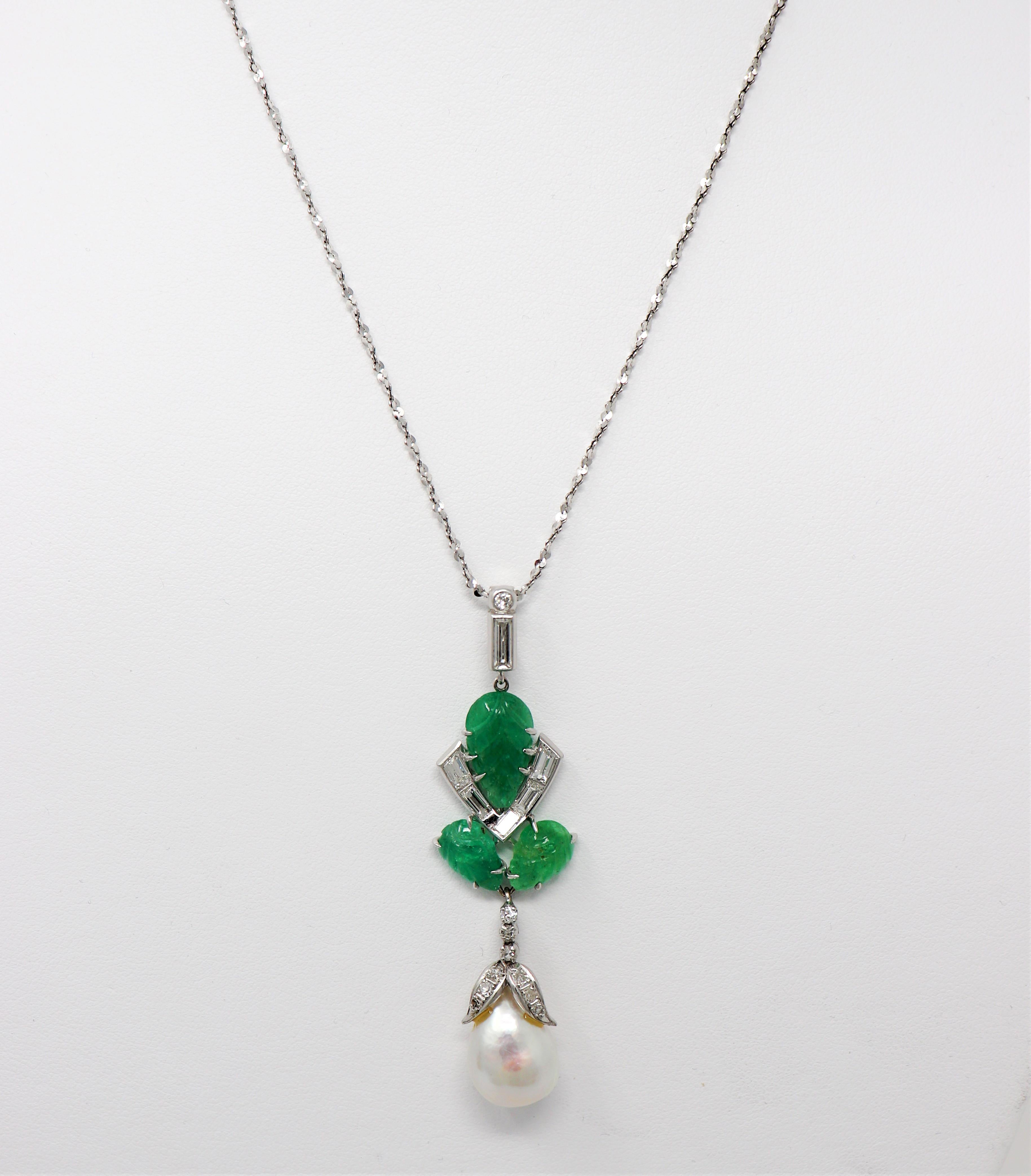 Elegant pendant necklace featuring natural diamonds, emeralds and a single large cultured baroque pearl. The elongated pendant dangles luxuriously on the neck while the accent diamonds catch the light and shimmer beautifully against the bright green