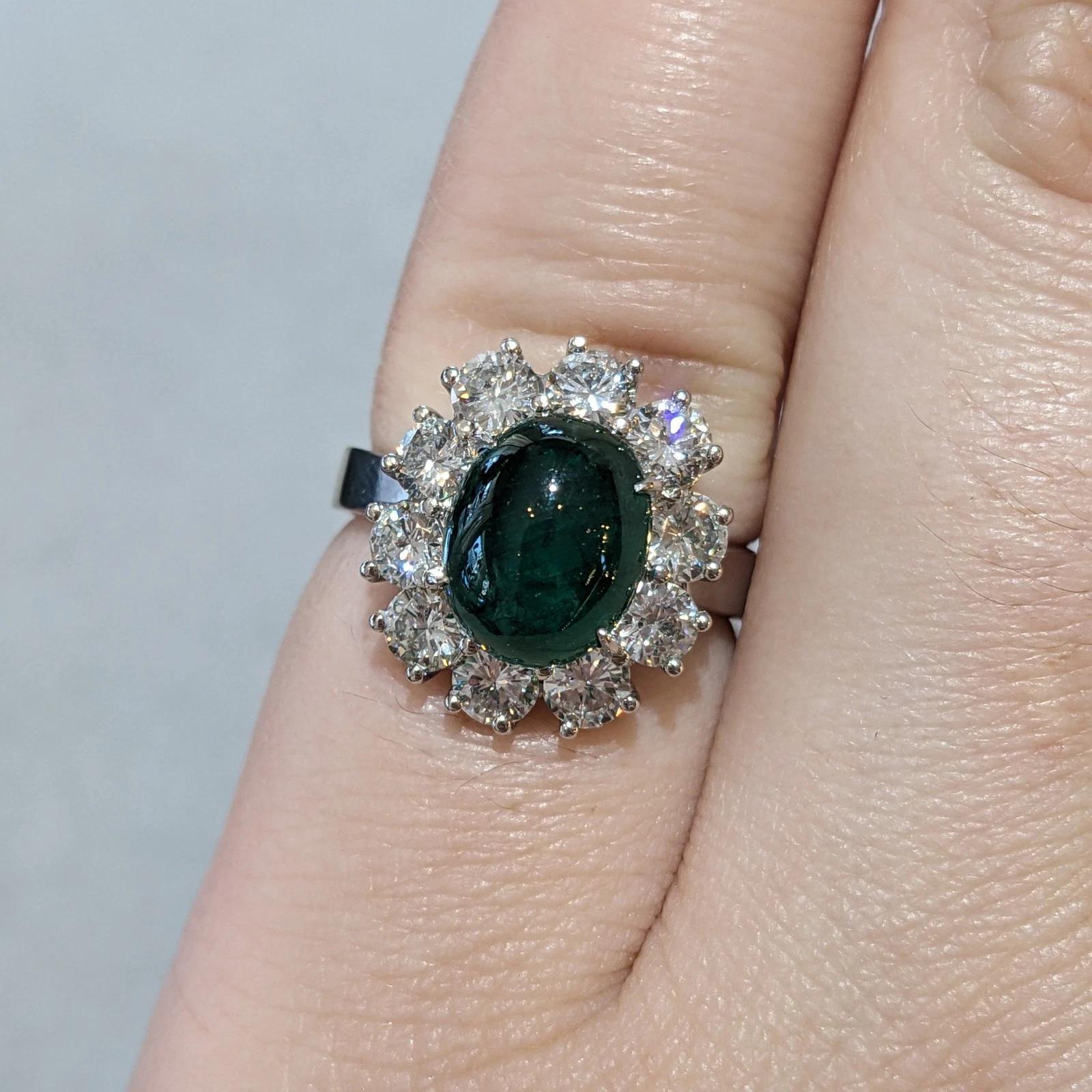GIA Emerald Cabochon 3.48 ct with 1.60 ct Round Diamonds in Platinum

Emerald Cabochon and Diamond Ring features one center Oval-shaped Emerald Cabochon weighing 3.48 carats, surrounded by a halo of 10 Round Brilliant Diamonds, all set in a Platinum