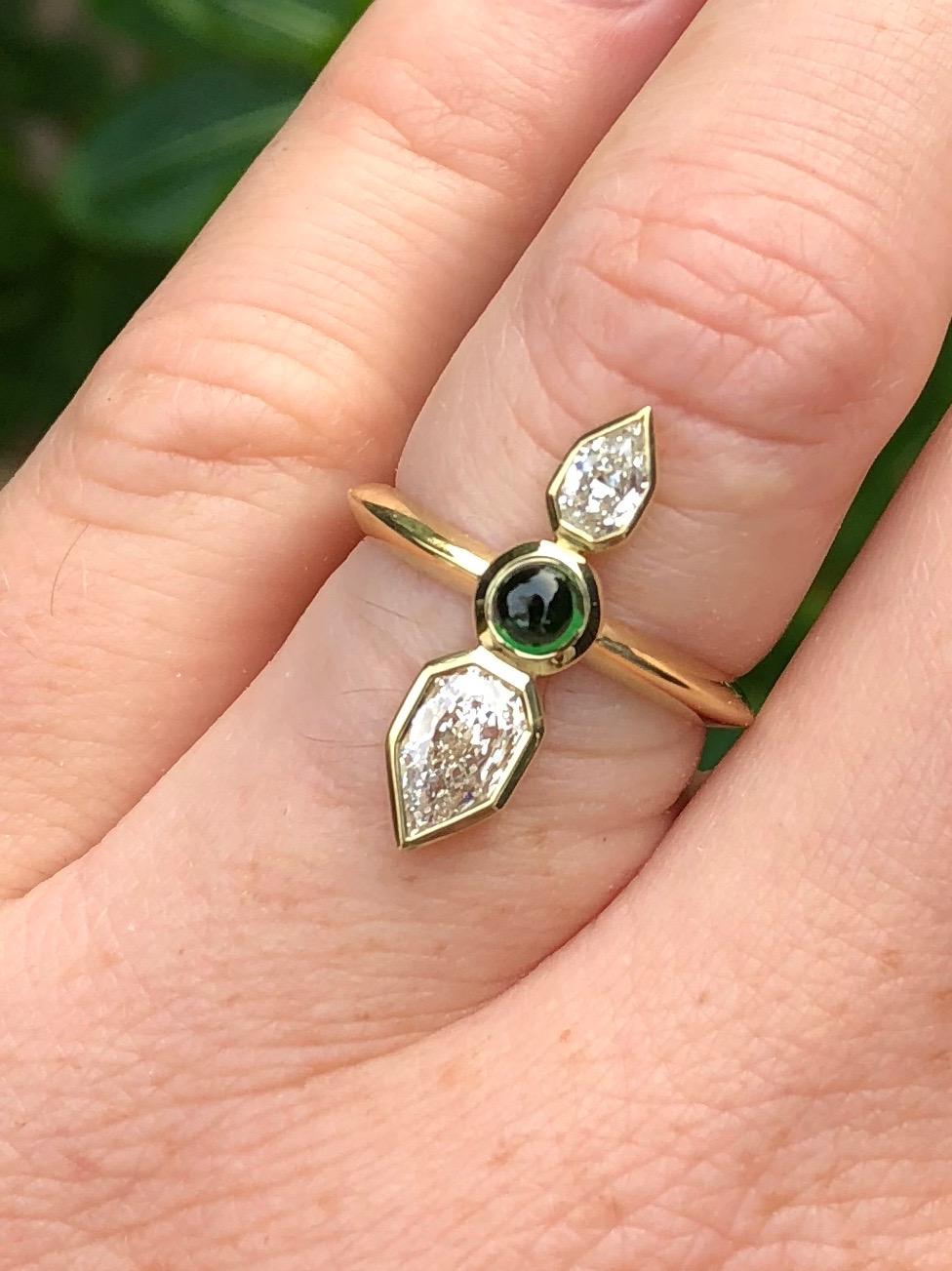 This ring is like an arrow on your finger. Made by hand (hand fabricated) in California with reclaimed and refined 18 karat gold, using a Tsavorite cabochon from Bridges Tsavorite in Kenya, and 2 special diamonds. These diamonds are formerly chipped
