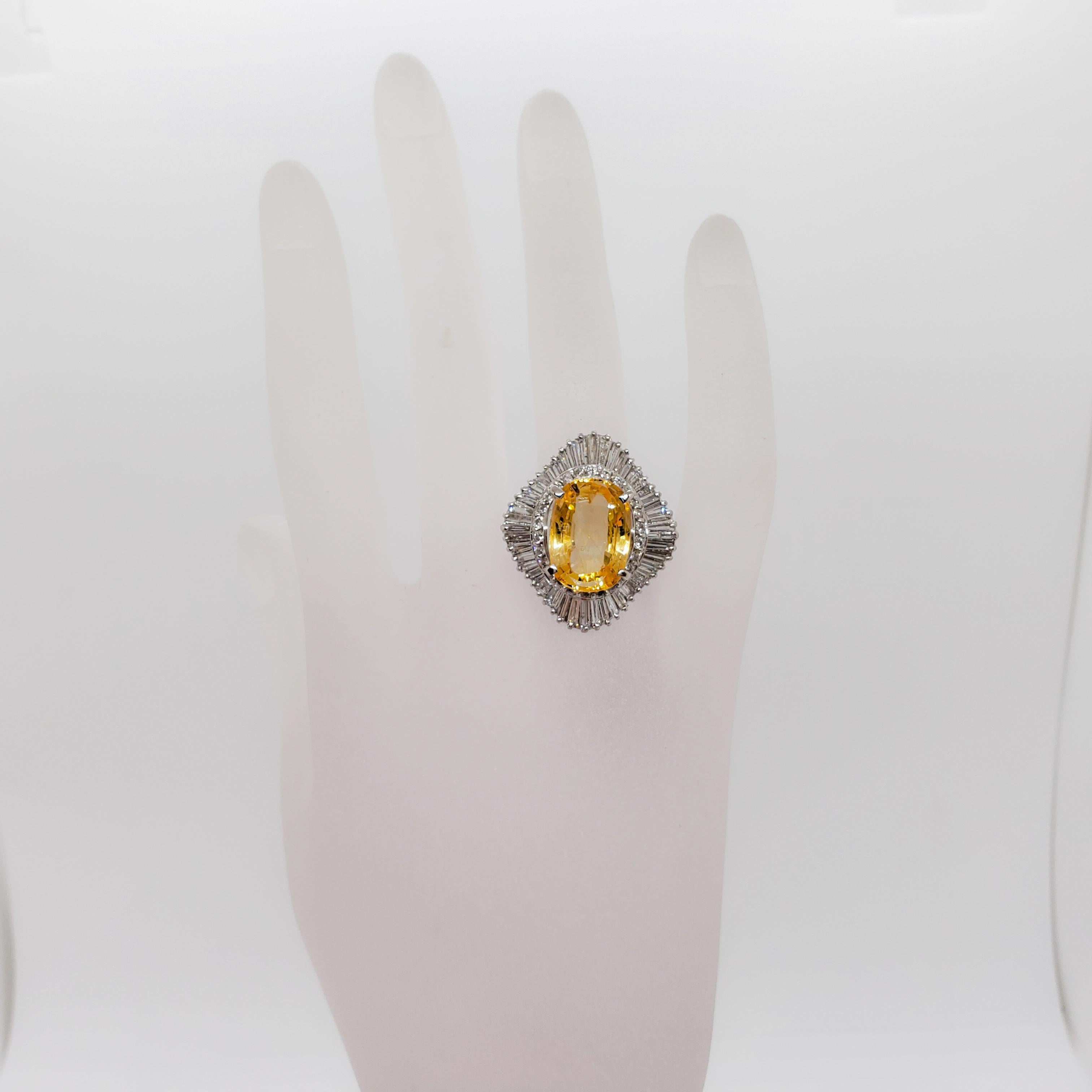 Stunning estate ring featuring a bright sunshine yellow 9.69 ct. yellow sapphire cushion with 2.45 ct. of good quality, white, and bright diamond rounds and baguettes.  Classic handmade design in platinum.  Ring size 7.5.  Comes with GIA report. 