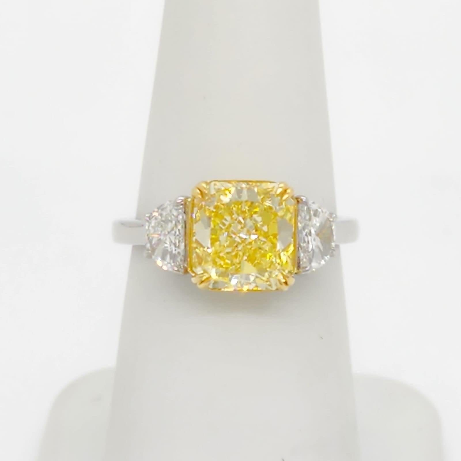Gorgeous 2.73 ct. fancy intense yellow diamond radiant with two 0.60 ct. white diamond half moon shapes.  GIA certified.  Ring size 6.5.