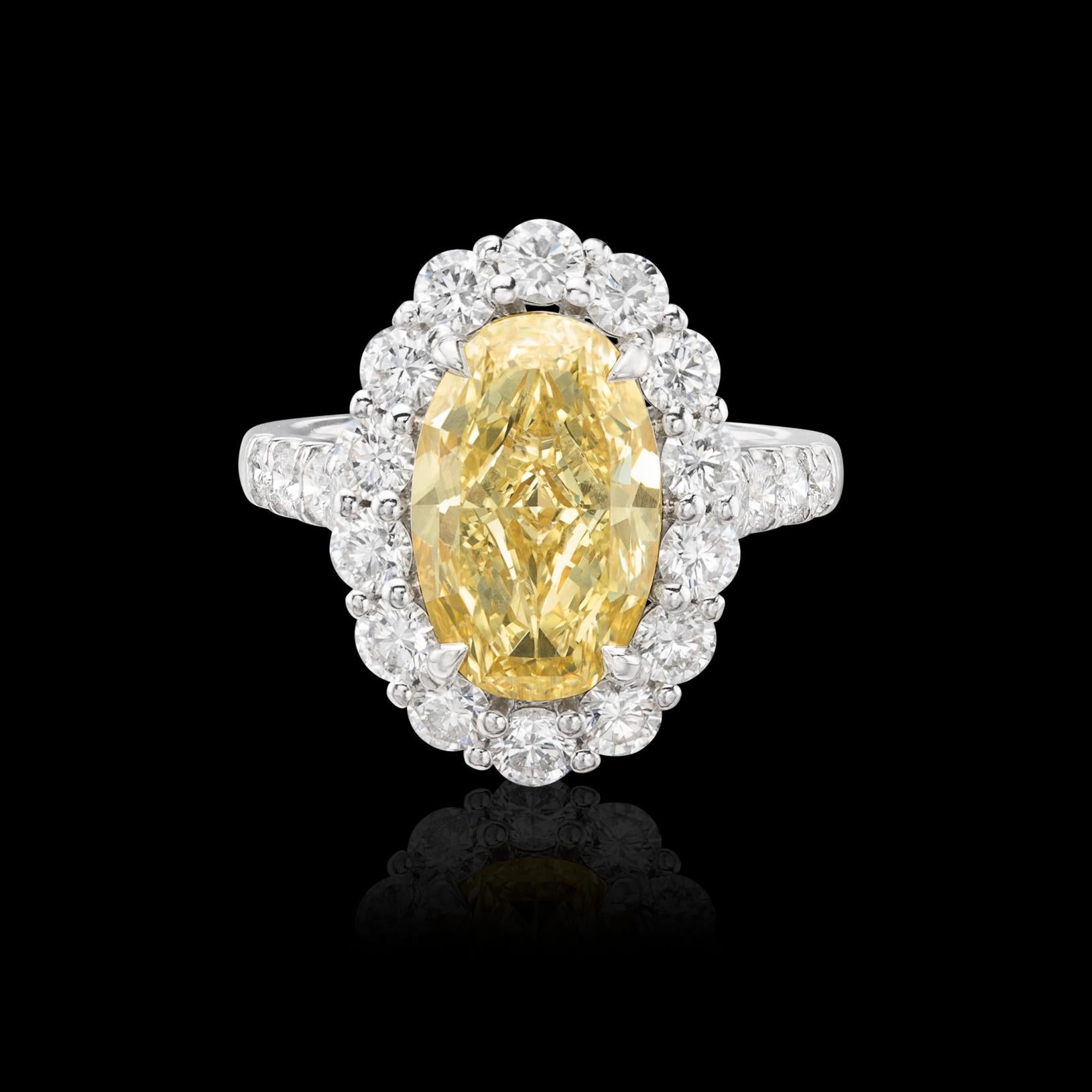 Beautiful platinum engagement ring in the Princess Di style! The 4.15-carat oval-cut fancy light yellow/SI1 diamond is set in 18k gold, and surrounded by 22 round brilliant-cut diamonds, continued down the shoulders, with a total weight of 5.91