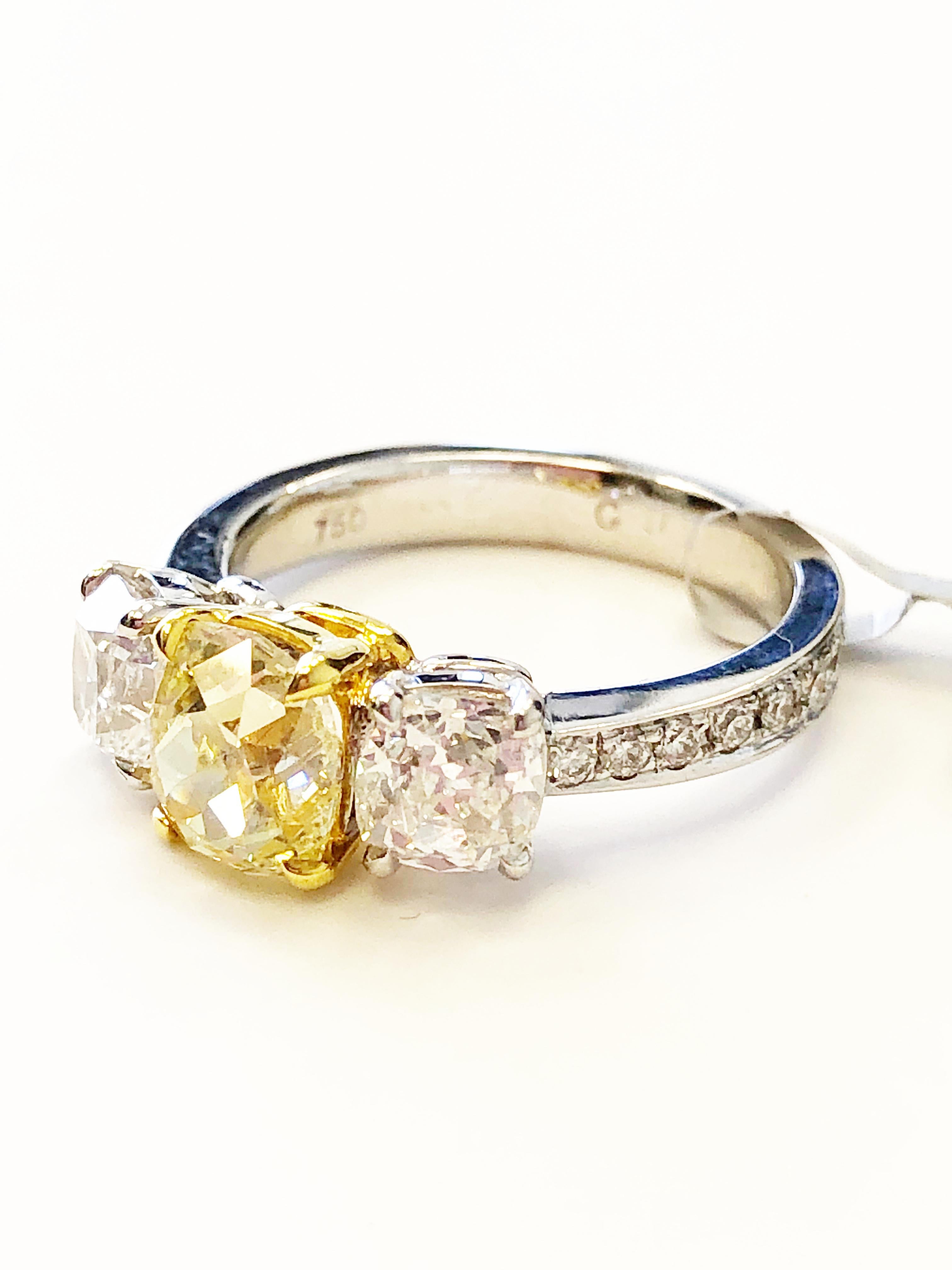 Gorgeous sunshine fancy yellow cushion weighing 1.45 carats with 1.63 carats of good quality white diamond rounds.  Handmade mounting in 18k two tone gold in size 6.  Beautiful ring with GIA certificate.

