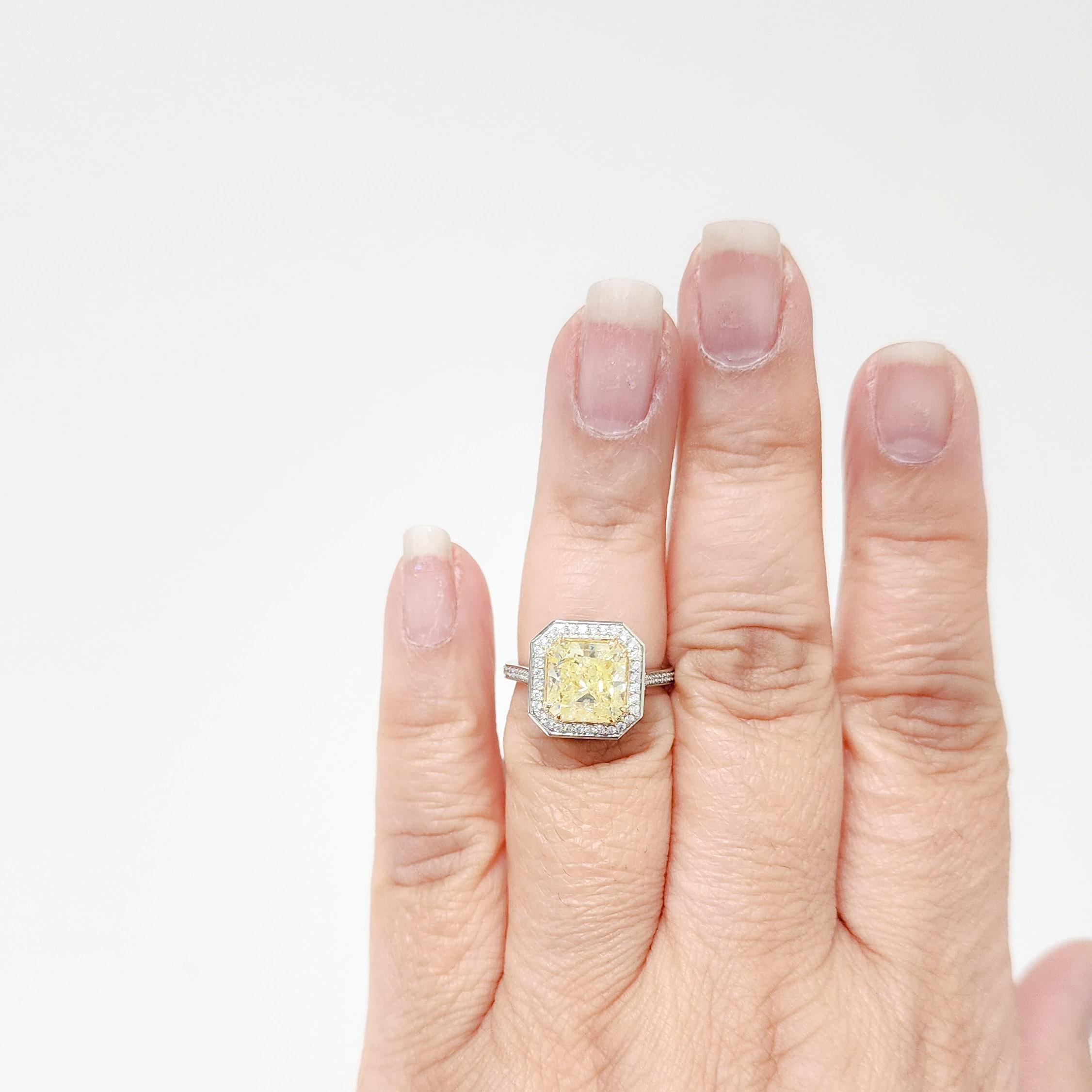 Beautiful 3.51 ct. GIA fancy yellow radiant diamond with 0.33 ct. good quality white diamond rounds.  Handmade in 18k yellow and white gold.  Ring size 6.25.  GIA certificate included.