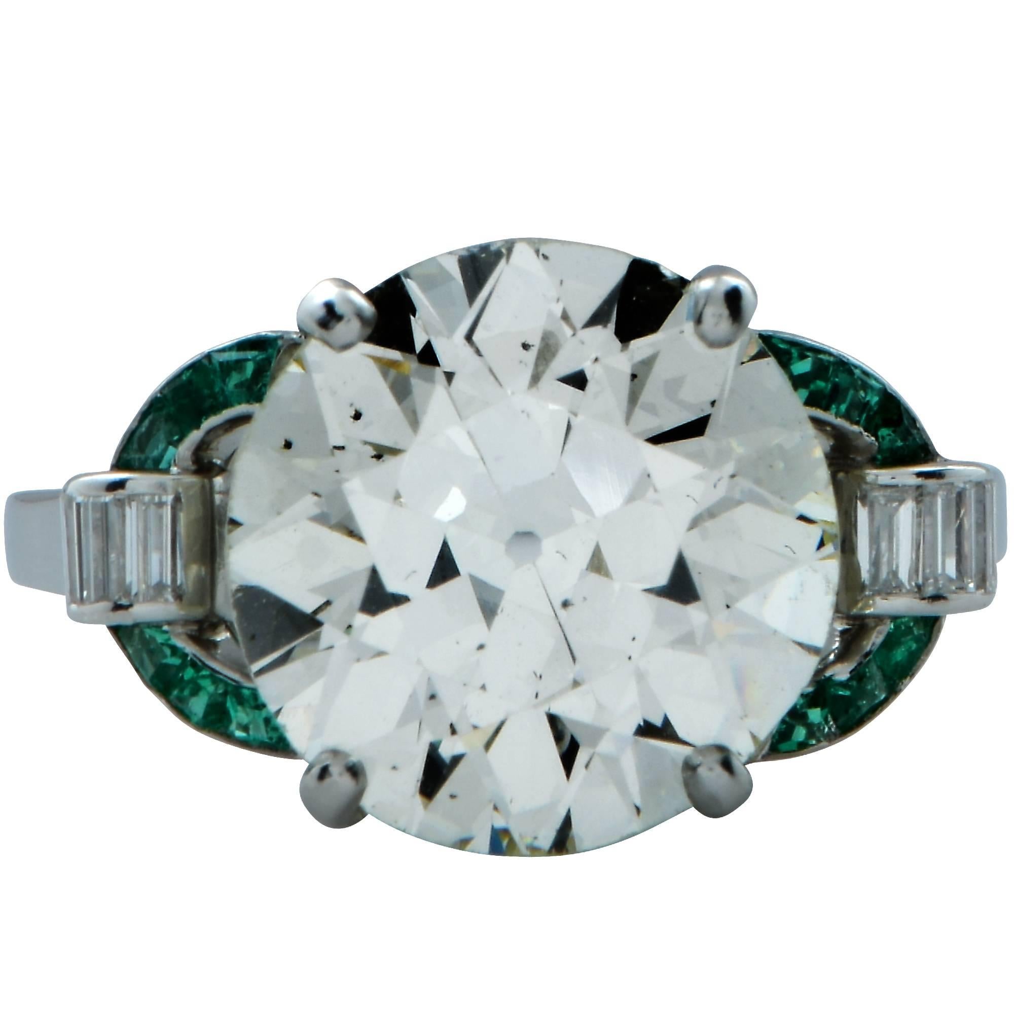 Platinum Art Deco engagement ring featuring a spectacular GIA graded 6.19ct European cut diamond, L color and SI1 clarity flanked by 12 carré cut emeralds weighing approximately .35cts and further accented by 6 baguettes weighing approximately