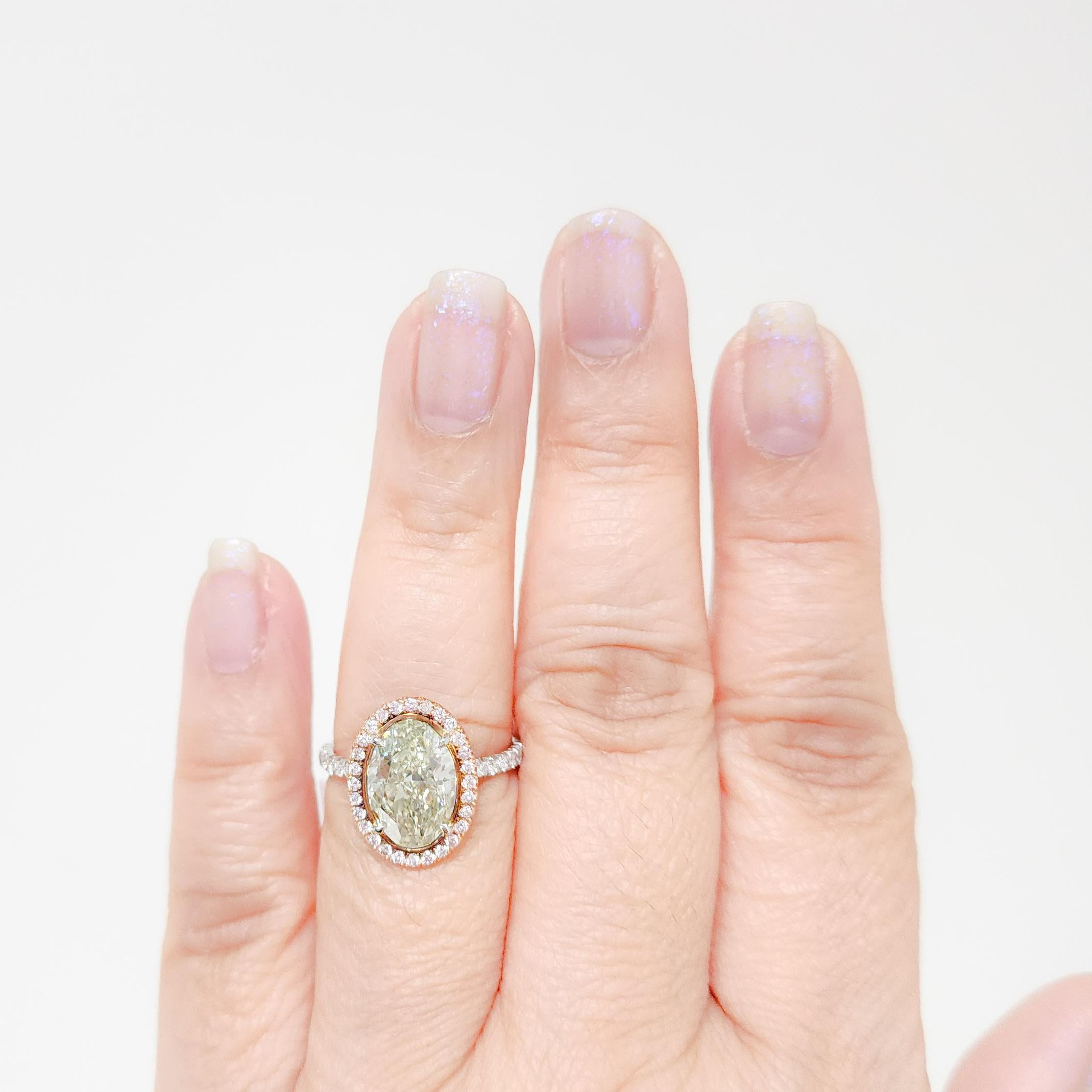 Stunning 3.49 ct. fancy yellow green oval SI1 with 0.25 ct. natural pink diamond rounds.  Handmade in platinum and 18k rose gold.  Ring size 7.  GIA certificate included.