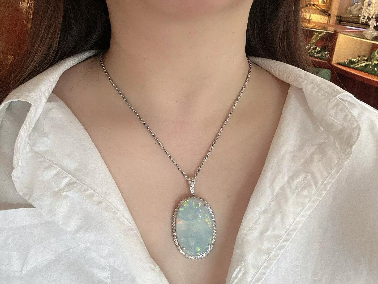GIA certified Grey Opal 59.90 carat with Diamond Halo Pendant in Platinum and 18k White Gold

Large Oval Grey Opal with Diamond Halo Pendant features a GIA certified Large Oval Grey Opal weighing 59.90 carats with a play of orange, lime green, blue,