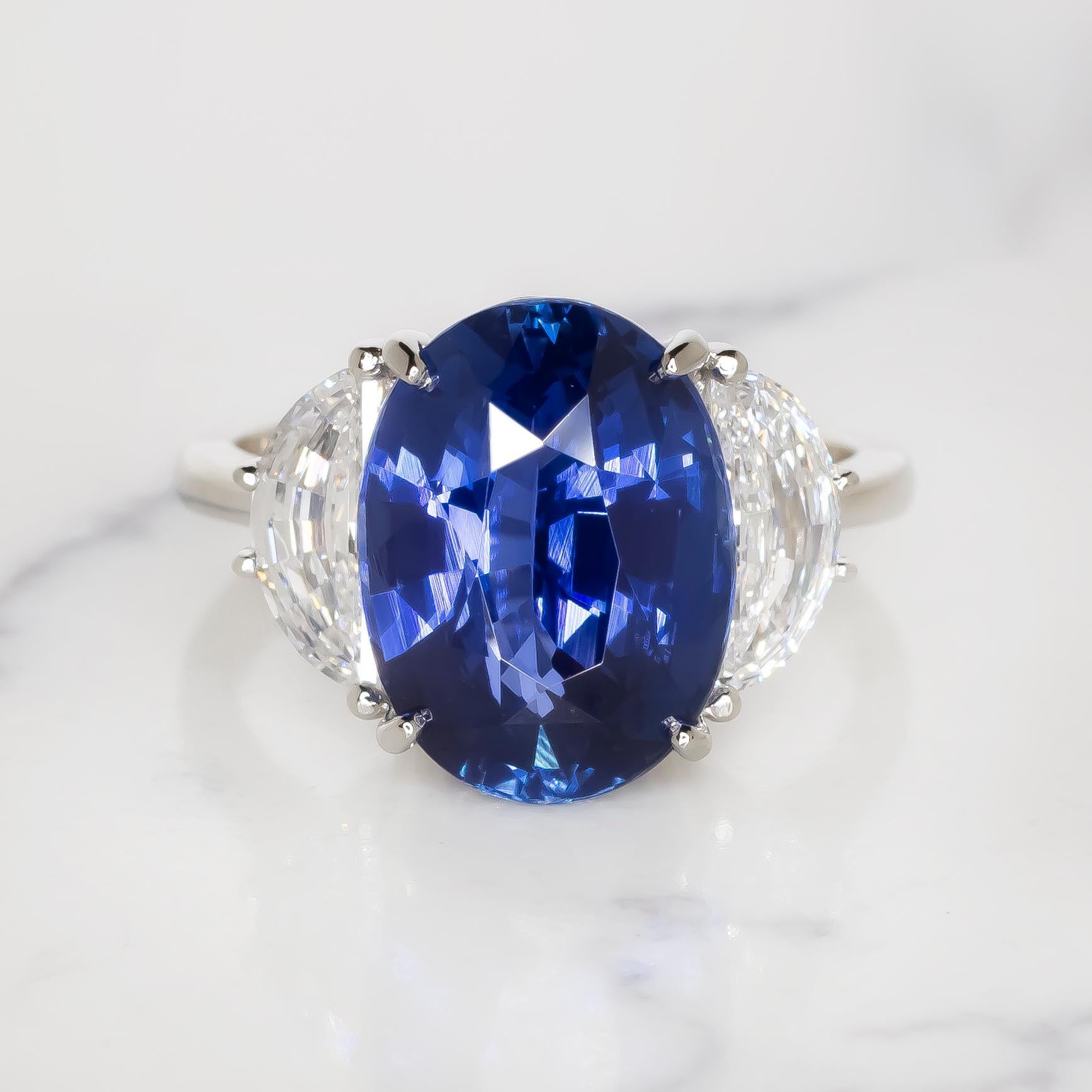 Prepare to be swept away by the extraordinary beauty of our GIA Certified 7 Carat Oval Blue Sapphire Diamond Ring, sourced directly from the illustrious mines of Ceylon. This magnificent creation is more than just a ring—it's a symbol of rare