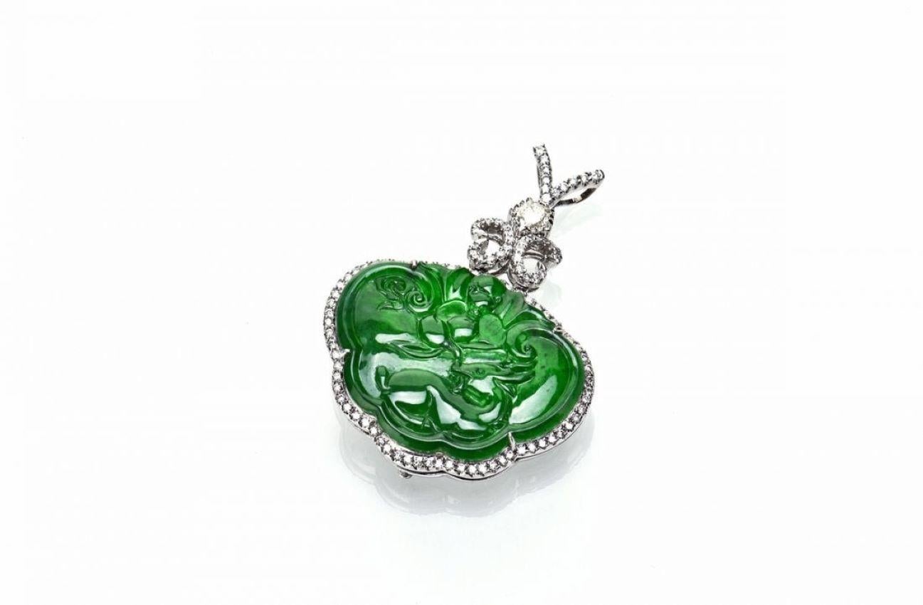 Questo ciondolo in giada omphacite è meticolosamente intagliato con motivi di pipistrelli, cervi e pesche, che simboleggiano felicità, prosperità, fortuna e longevità. Presenta accenti di diamanti sulla parte superiore, completati da diamanti a