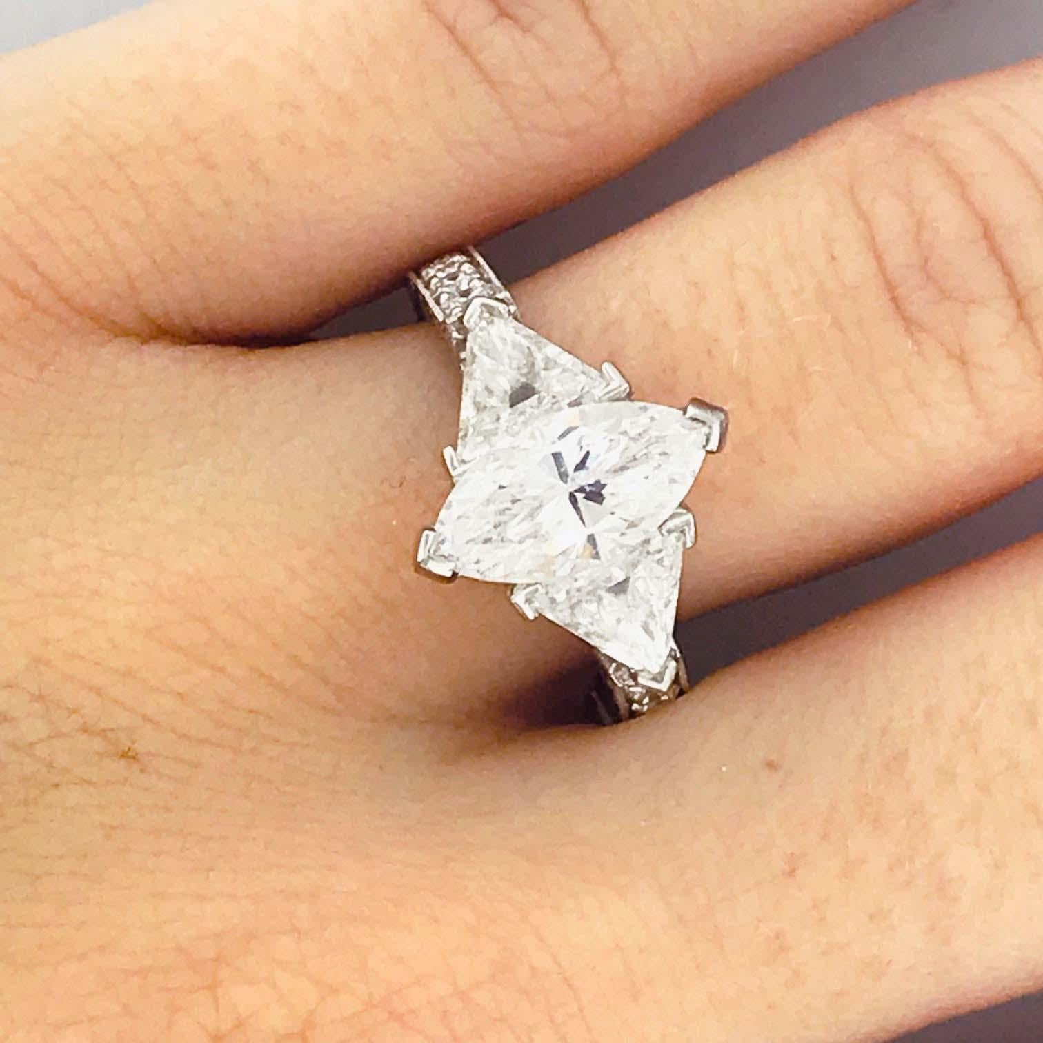 This is a gorgeous CUSTOM, ONE OF A KIND design, three stone diamond engagement ring in platinum.  This marquise and trillion diamond three stone ring has a Marquise diamond set in the center. The marquise diamond is a high color grade and high