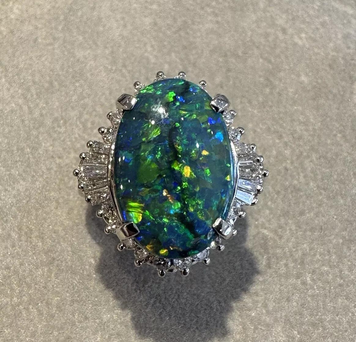 GIA certified Natural Black Opal 6.23 ct and Diamond Cocktail Ring in Platinum 

Natural certified Black Opal Ring features a center Oval Cabochon Black Opal with flashes of Green, Yellow, Orange, and Blue surrounded with Round and Baguette