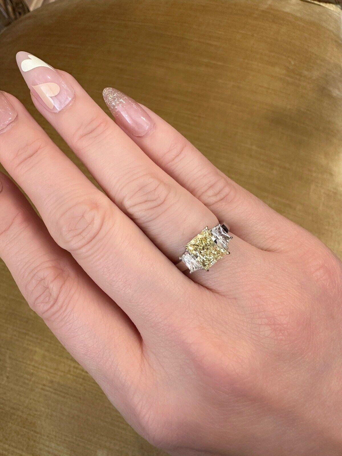 GIA Natural Fancy Yellow Diamond 2.31 carat with Side Diamonds in Platinum

Fancy Yellow Diamond Ring features a 2.31 carat Natural Fancy Yellow Diamond with a Rectangular Modified Brilliant-cut in the center, accented by two Trapezoid-shaped White