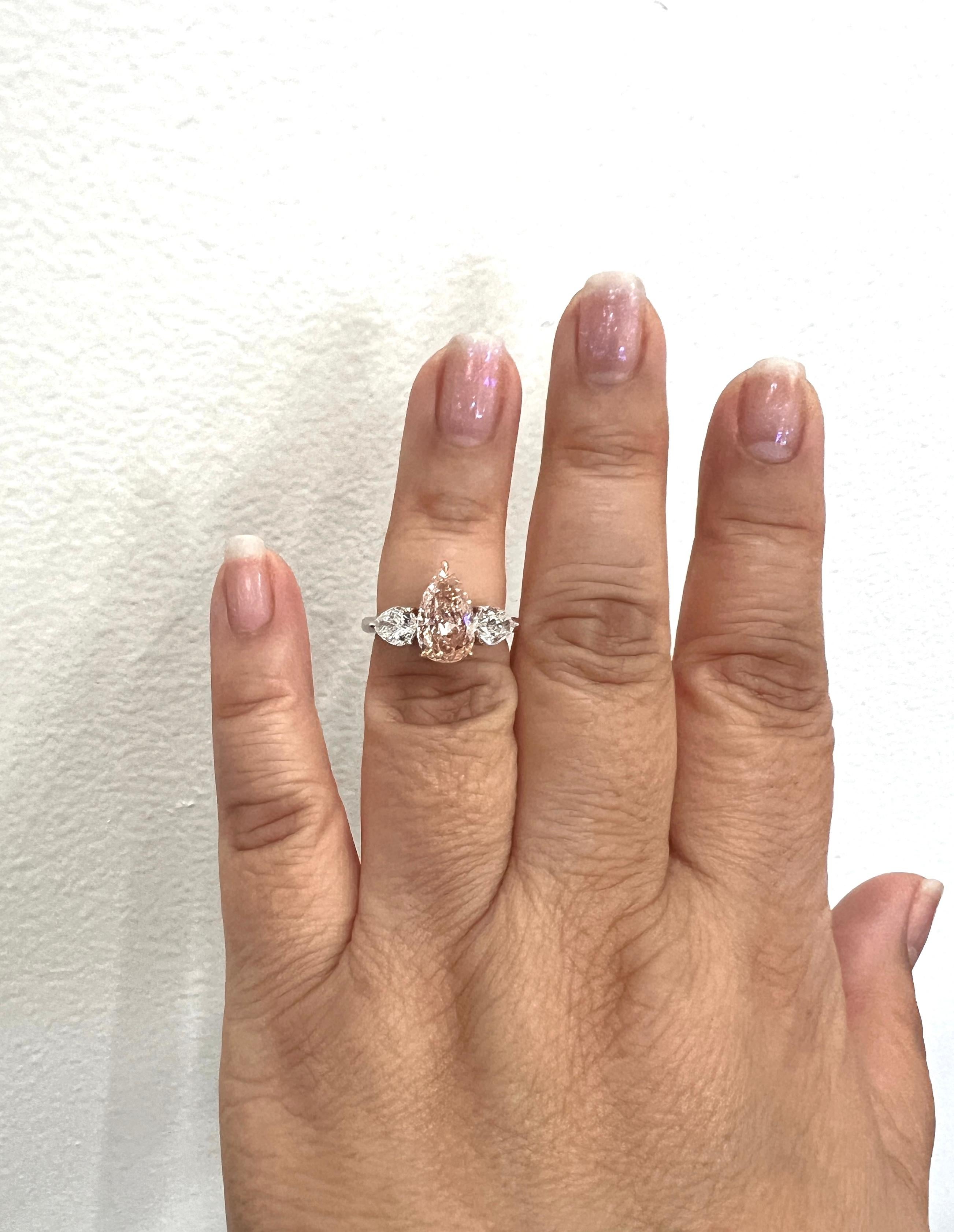 Absolutely breathtaking 2.78 ct. VS1 fancy orangy pink pear shape diamond with two 1.41 ct. F VS2 white diamond pear shapes.  Handmade in platinum and 18k rose gold.  Ring size 6.  This ring is stunning in real life!  GIA certificates included.