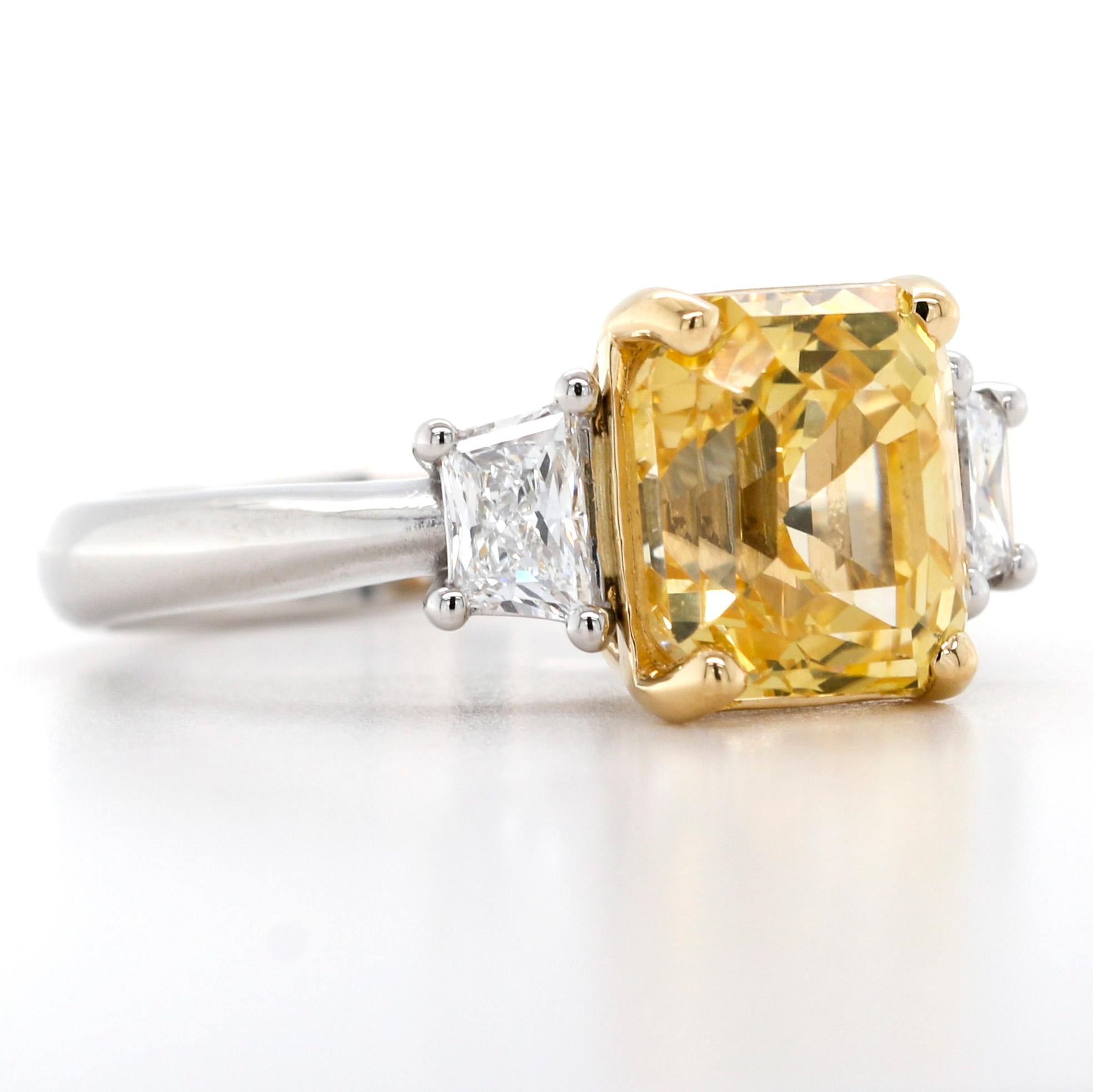 Stunning women's yellow sapphire and diamond ring crafted in platinum and 18-karat white gold. This beautiful ring features a 5.59-carat octagonal step-cut natural unheated yellow sapphire with a trapeze diamond on the sides--polished metal