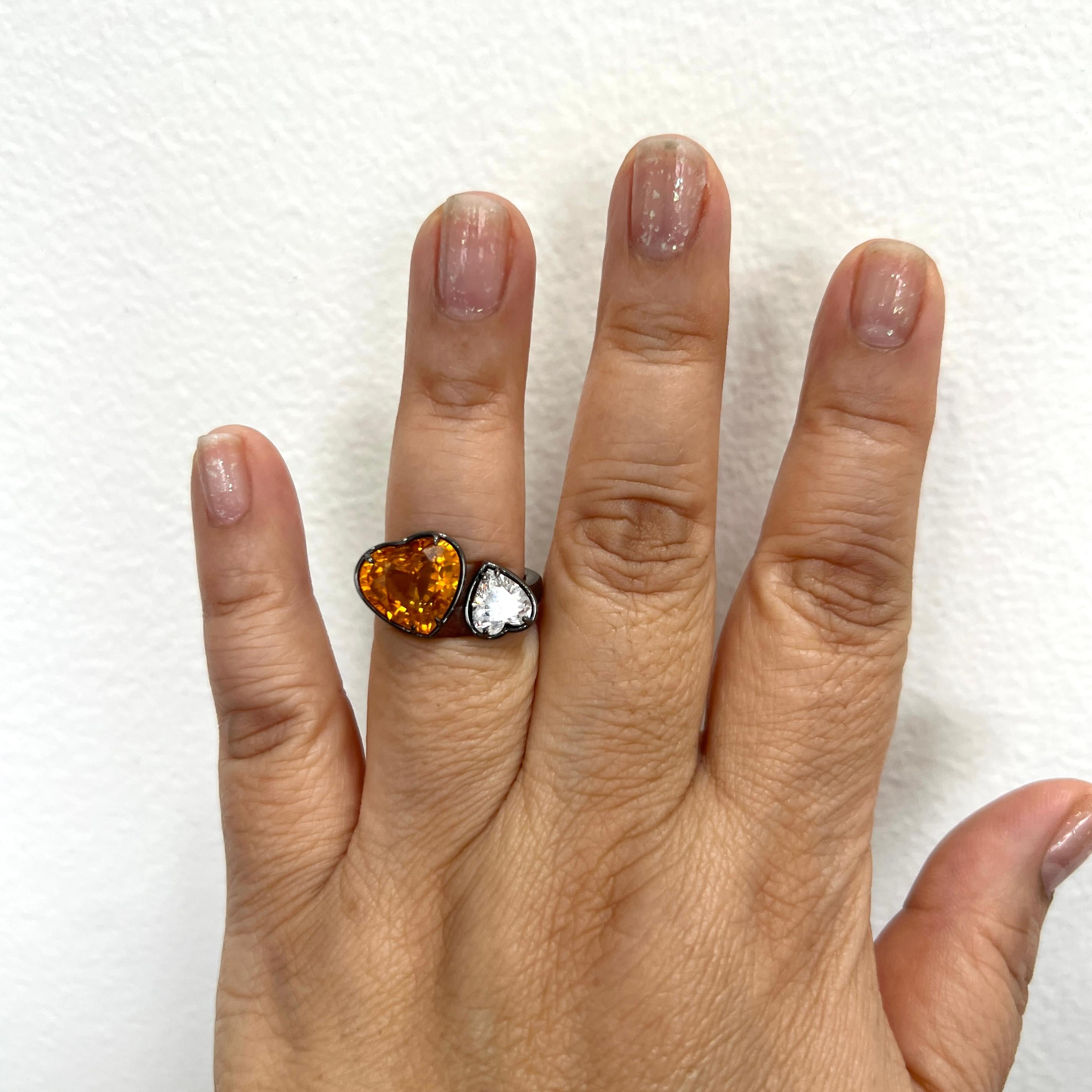 Gorgeous toi et moi ring with a 7.17 ct. GIA orange sapphire heart and 1.28 ct. GIA D SI1 white diamond heart.  Handmade in 18k yellow gold and black rhodium.  Ring size 6.5.  GIA certificates included.